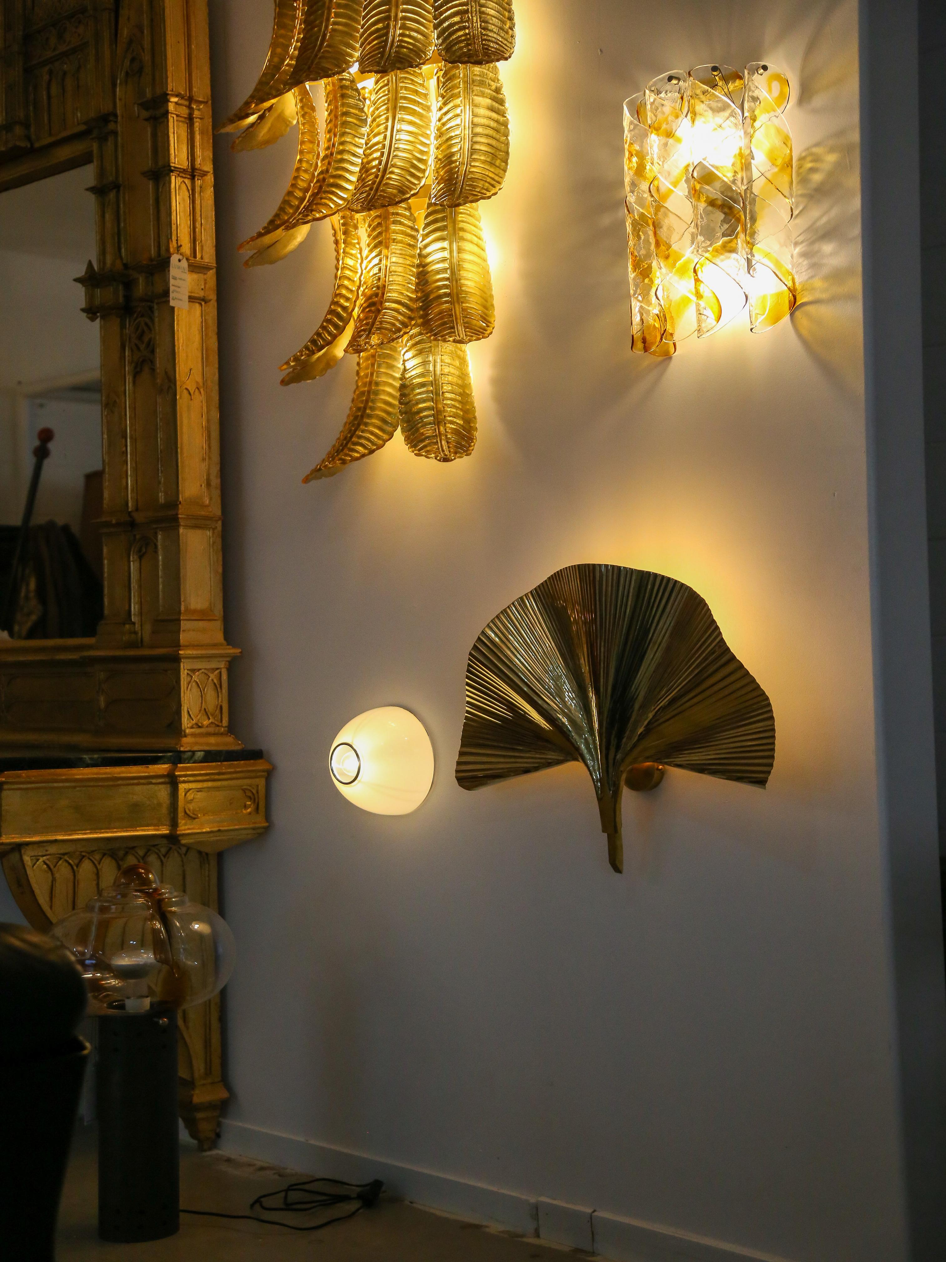 Contemporary large design wall lamp entirely made of brass with one  Ginko leaf.

This combination of brass and botanical elements creates a stylish design and nature-inspired lighting fixture. The Ginkgo Biloba is a tree known for its distinctive