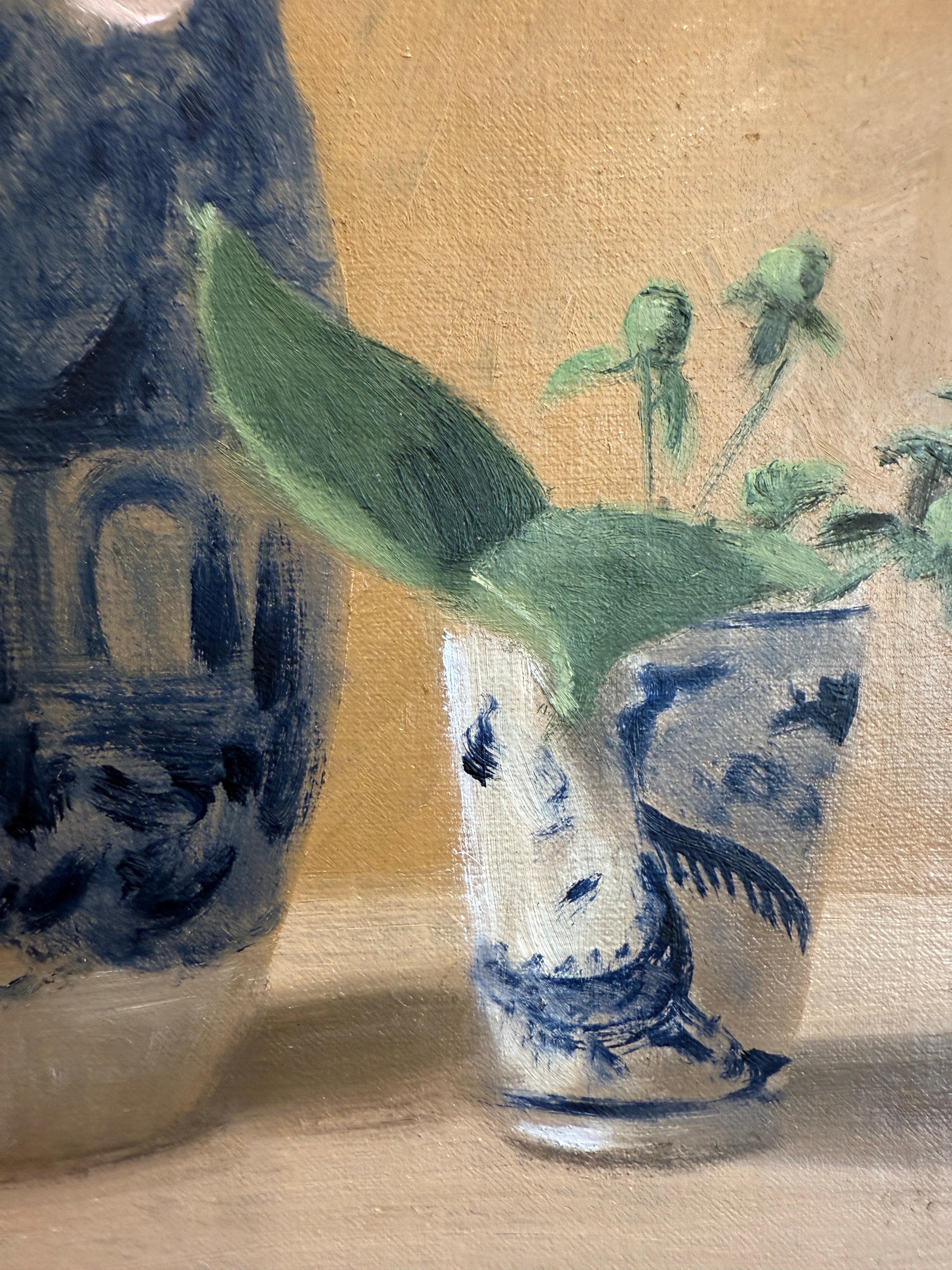 This piece is an original oil painting on panel. It features several blue and white vessels, which are the artist's trademark and come from her collection of antique ceramics, and peonies grown in her garden. The piece is framed in a pale gold