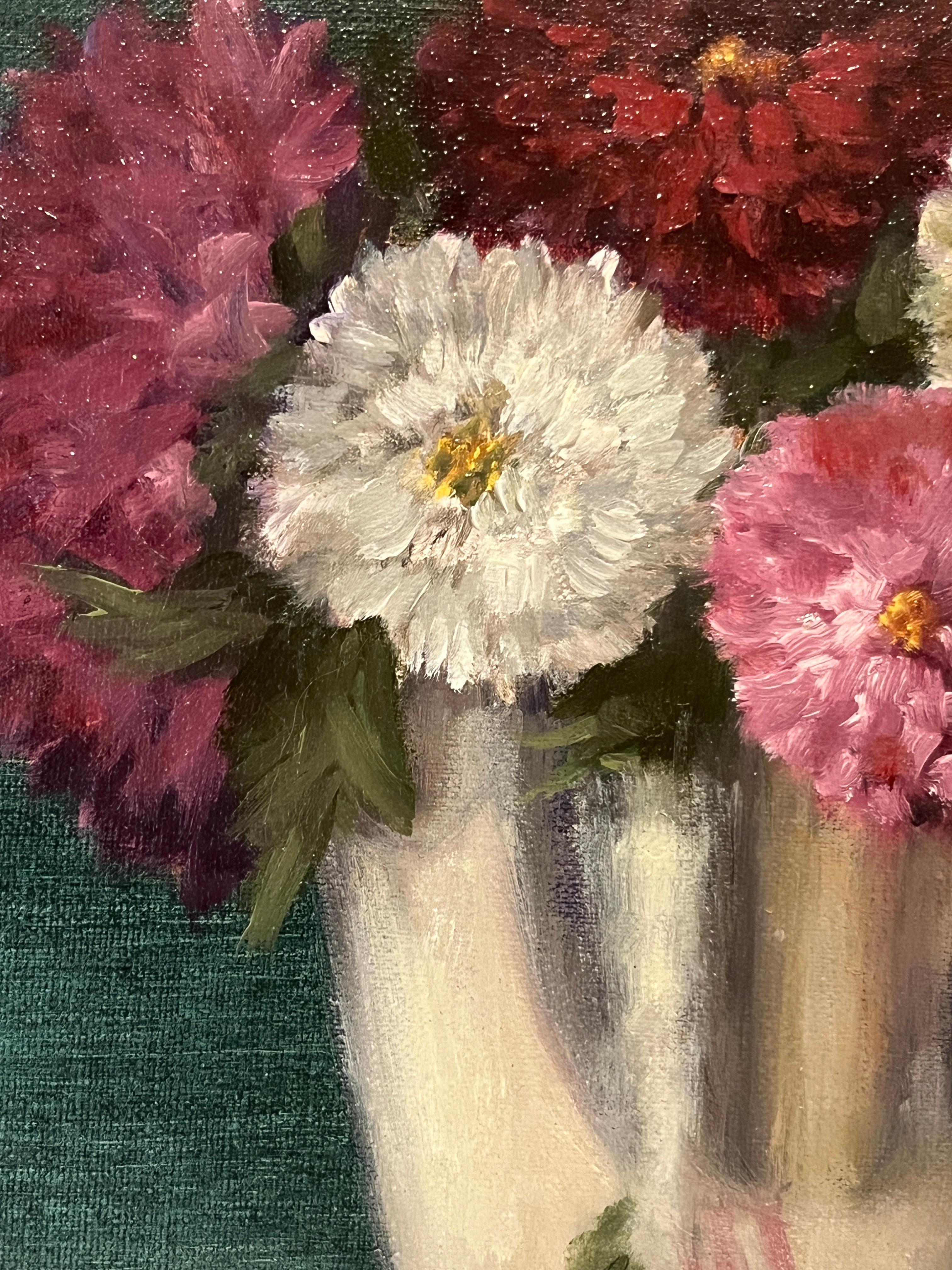 This is an original oil painting on a linen panel. Mums, the traditional flower of All Saints Day in France, are pictured in a reflective silver cup. A jewel-like deep green-blue background adds richness to the piece.

 Ginny Williams has a degree