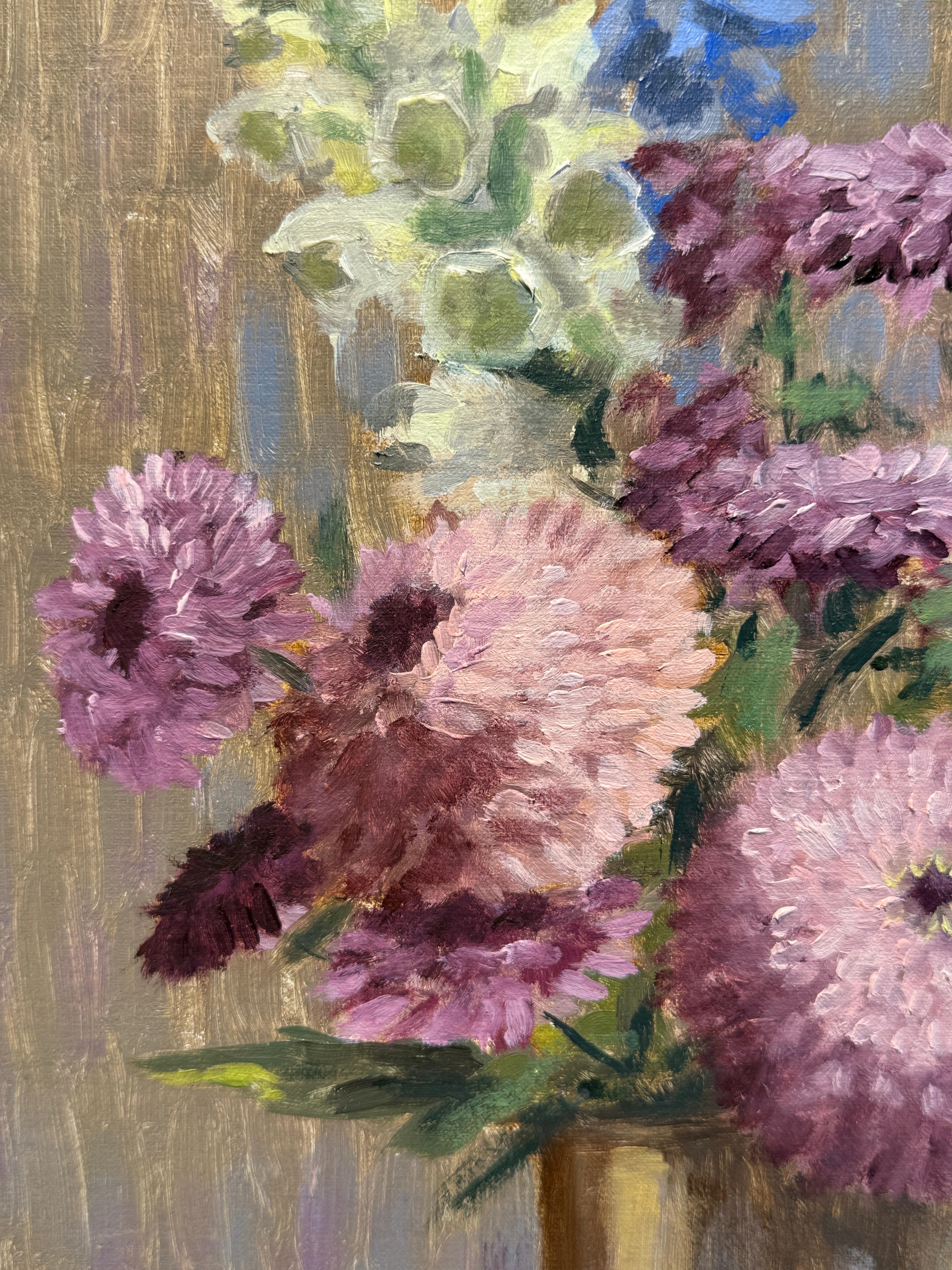 Questo pezzo è un dipinto a olio originale su pannello di lino. Un bouquet di fiori primaverili nei colori del rosa, del pervinca e del crema.  in una coppa d'argento illuminano la scena. Incorniciato in una cornice d'argento caldo dipinta a mano