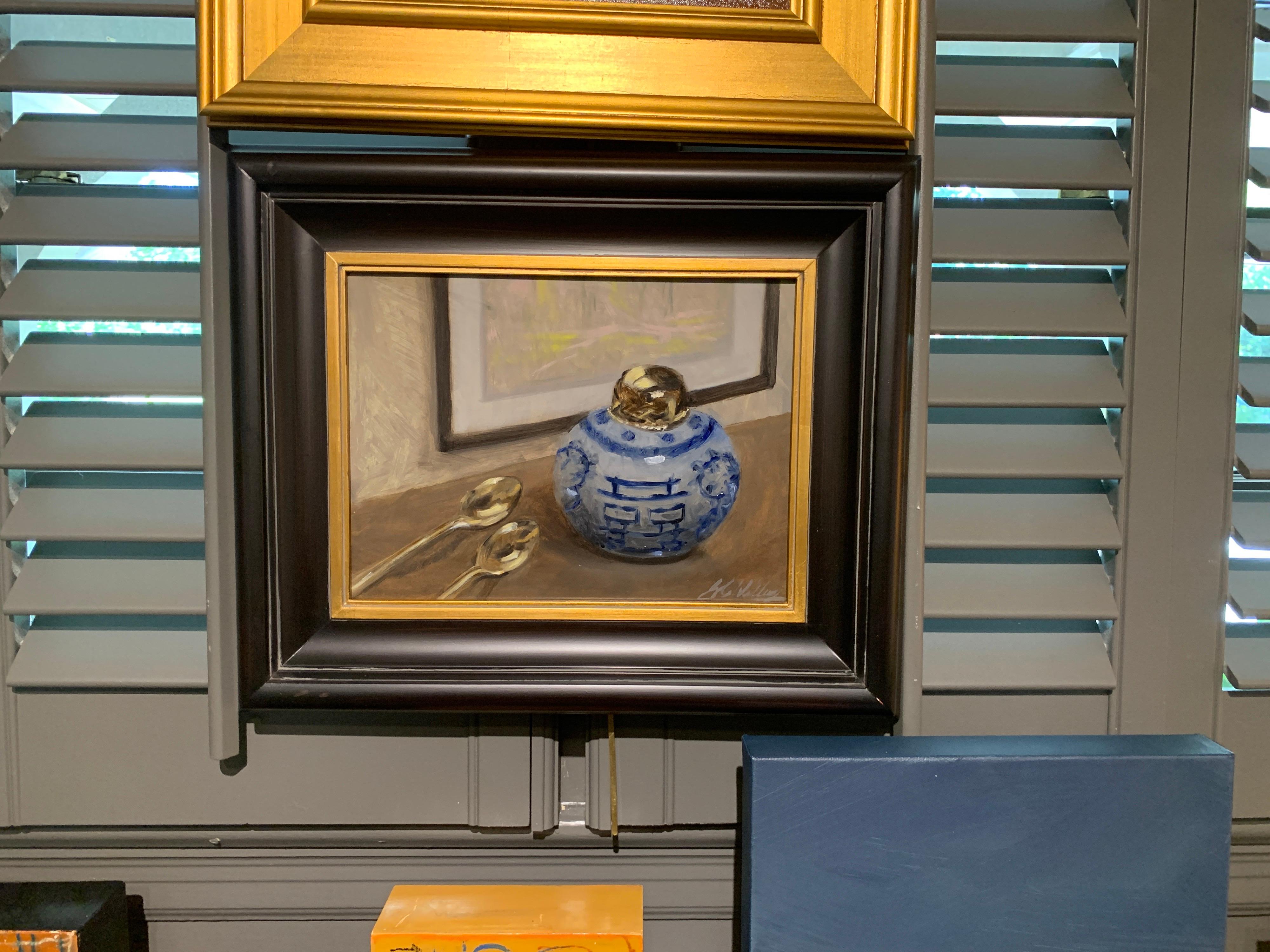 'Still Life With Blue and White' is a small framed representational oil on linen panel still life painting created by American artist Ginny Williams in 2020. Featuring a palette made of blue, neutrals and white, accented by black and brown colors,