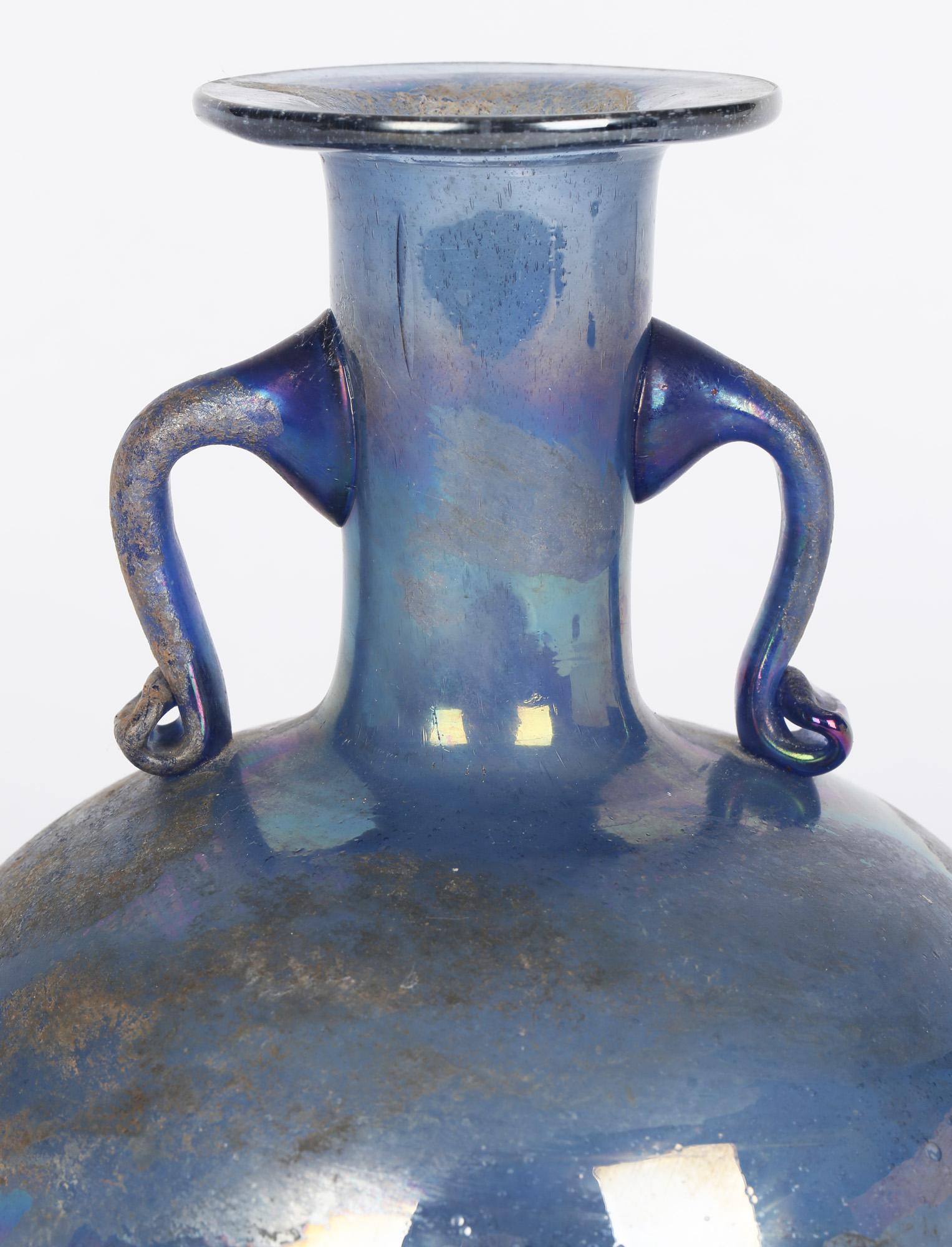 Italienische Scavo-Vase mit zwei Henkeln aus Muranoglas von Gino Cenedese (Italiener, 1907-1973) aus der Zeit um 1960. Die Vase ist aus mundgeblasenem, blau irisierendem Glas mit Blasen und anderen Einschlüssen und imitiert frühes römisches Glas.