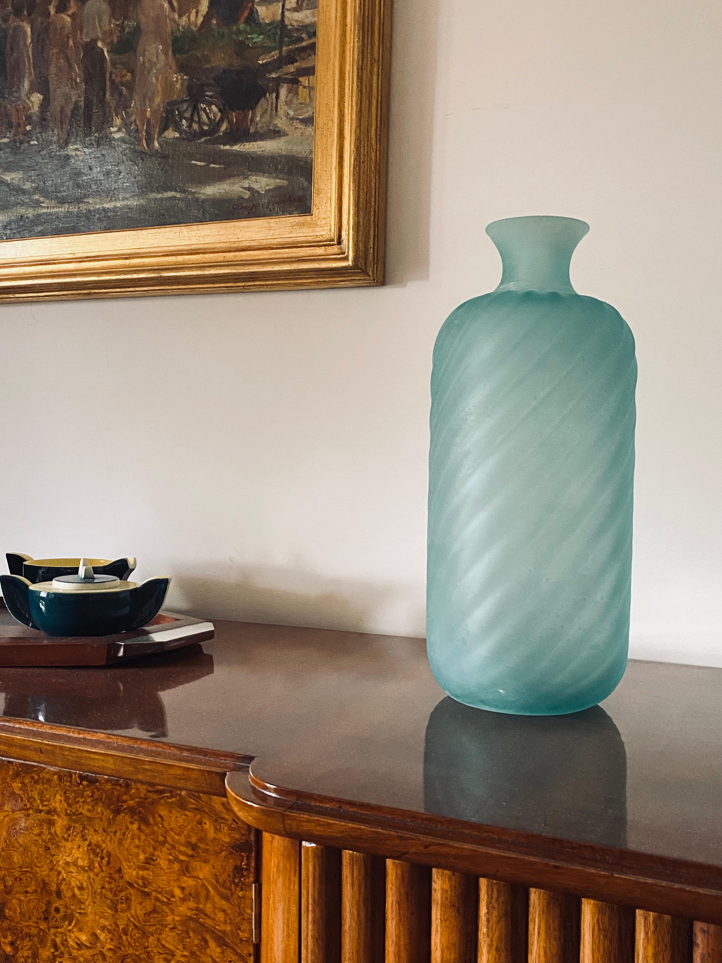 Vase en forme de bouteille en verre dépoli de Murano vert d'eau conçu par Gino Cenedese

Cenedese, Murano Italie. 1970 circa

Verre vert givré avec des rudentations en spirale à l'extérieur.

Signature gravée sous la base.

Label 