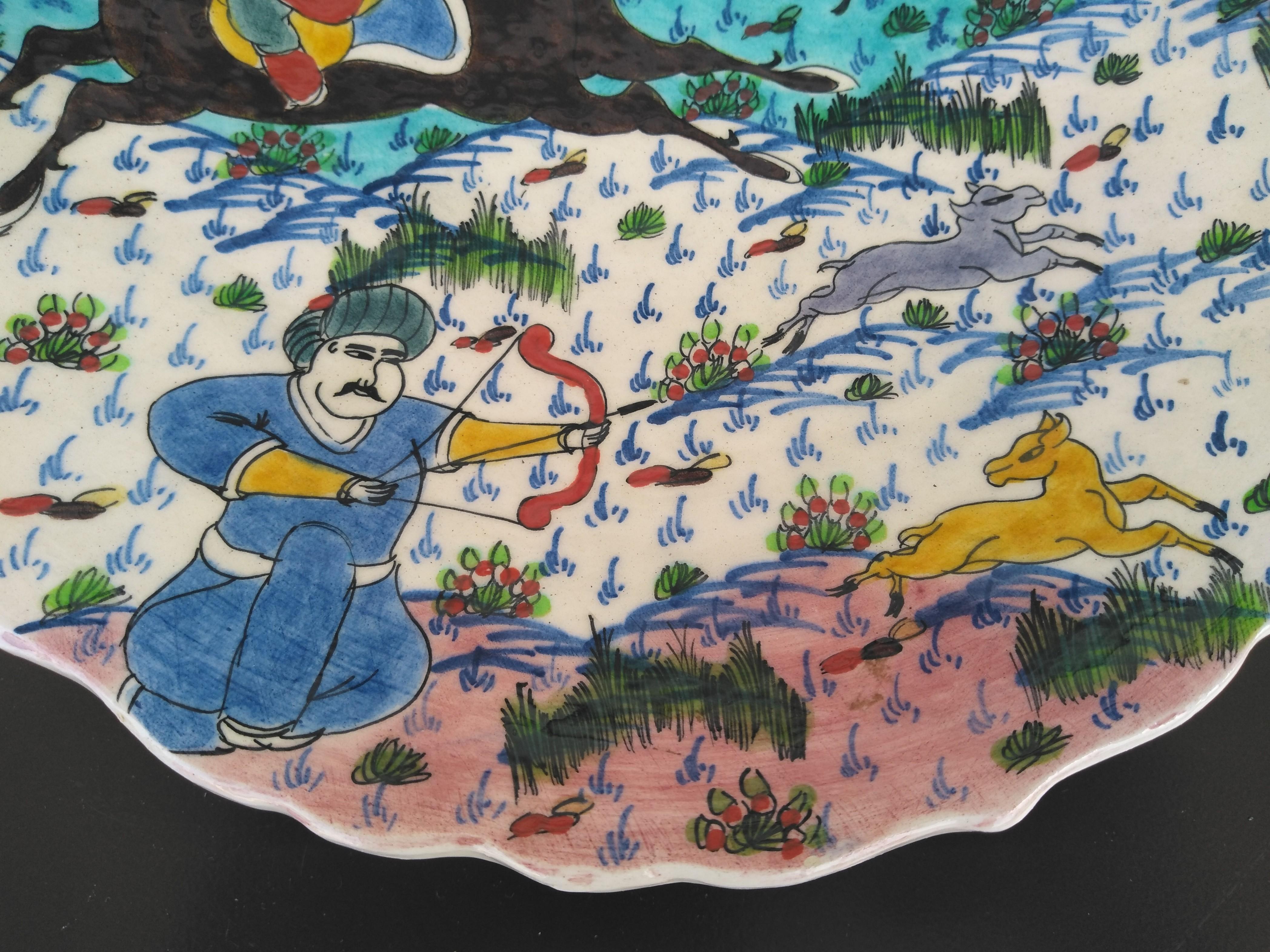 Un bonito ejemplo de la época histórica turca representada en un estilo de arte popular. El plato tiene un borde ondulado y está pintado a mano por el artista. Está firmado en el reverso.