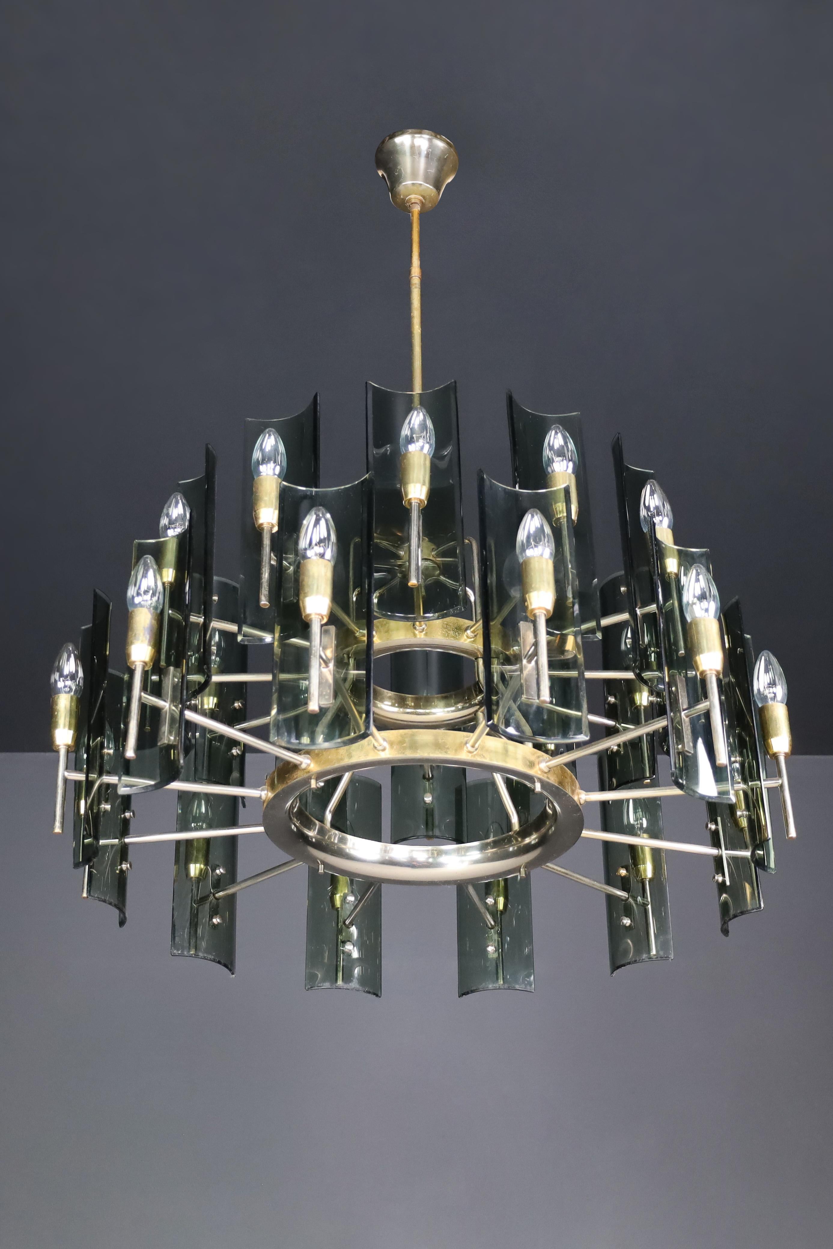 Gino Paroldo for Fontana Arte Large Chandelier in Brass and Curved Glass, Italy 1950s

Italian designer Gino Paroldo created a remarkable large chandelier made of brass and glass in the 1950s. This sculptural piece is a perfect representation of