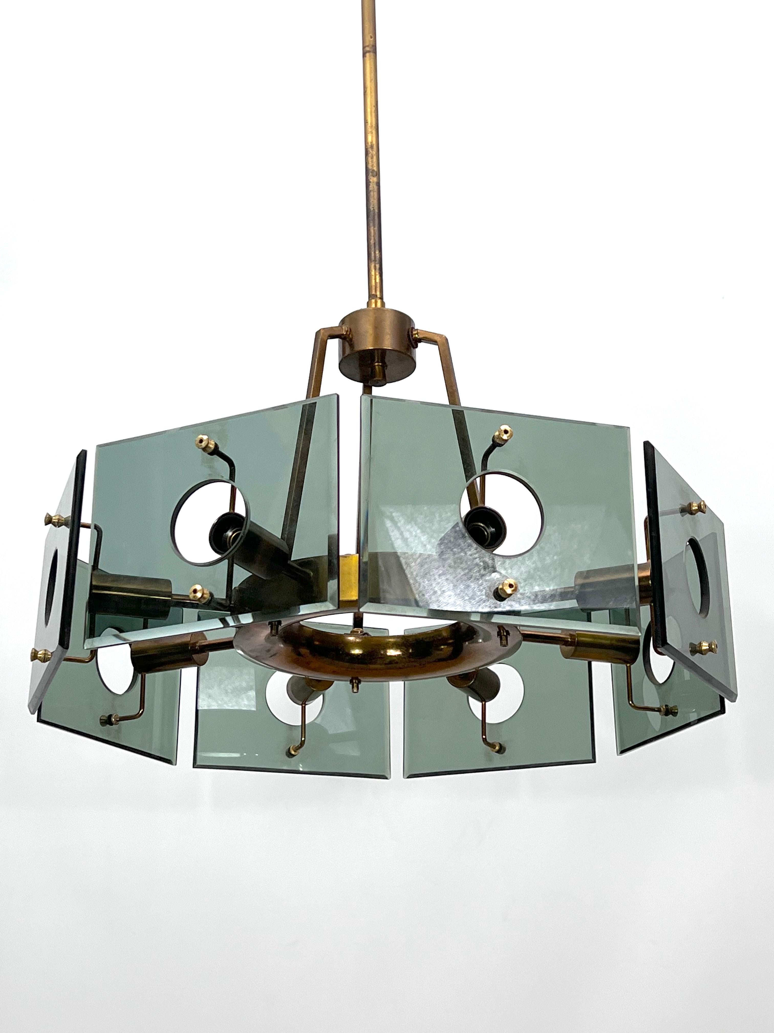 Produced in Italy during the 60s, this round chandelier model 4027 with eight arms was designed by Gino Paroldo for Dino Dei as shown in the original advertisement. It is in very good vintage condition with original patina and normal trace of age