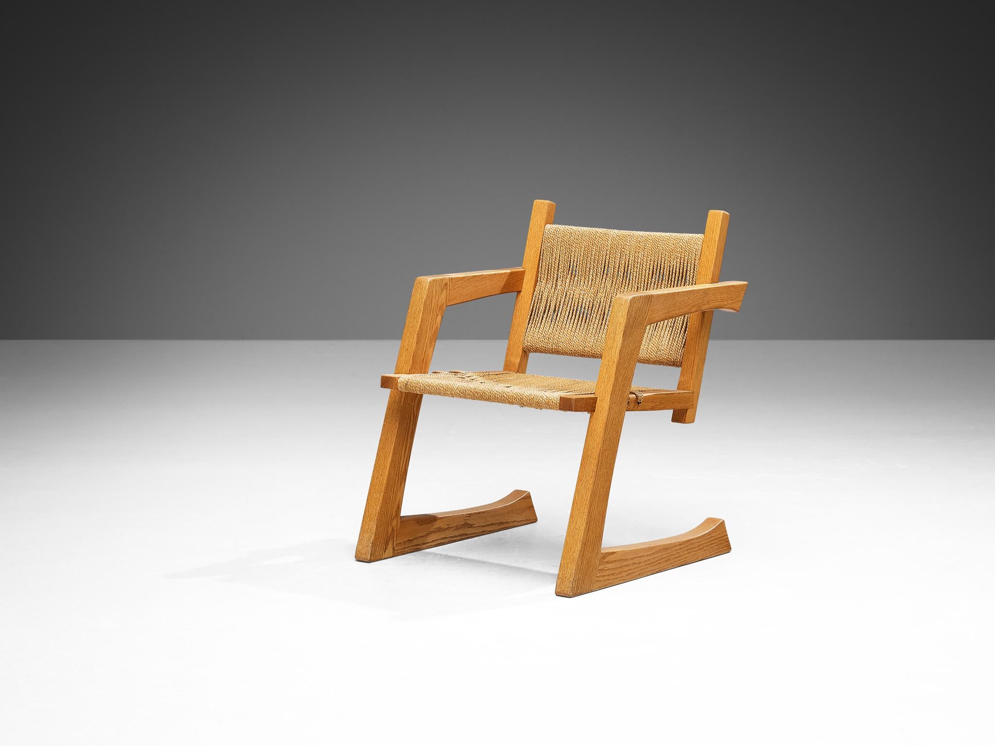Gino Russo, dining chair, oak, woven seagrass, United States, circa 1984

This armchair is designed by the Italian American furniture designer Gino Russo. The frame of this piece of furniture is made from oak and features an open, cantilever