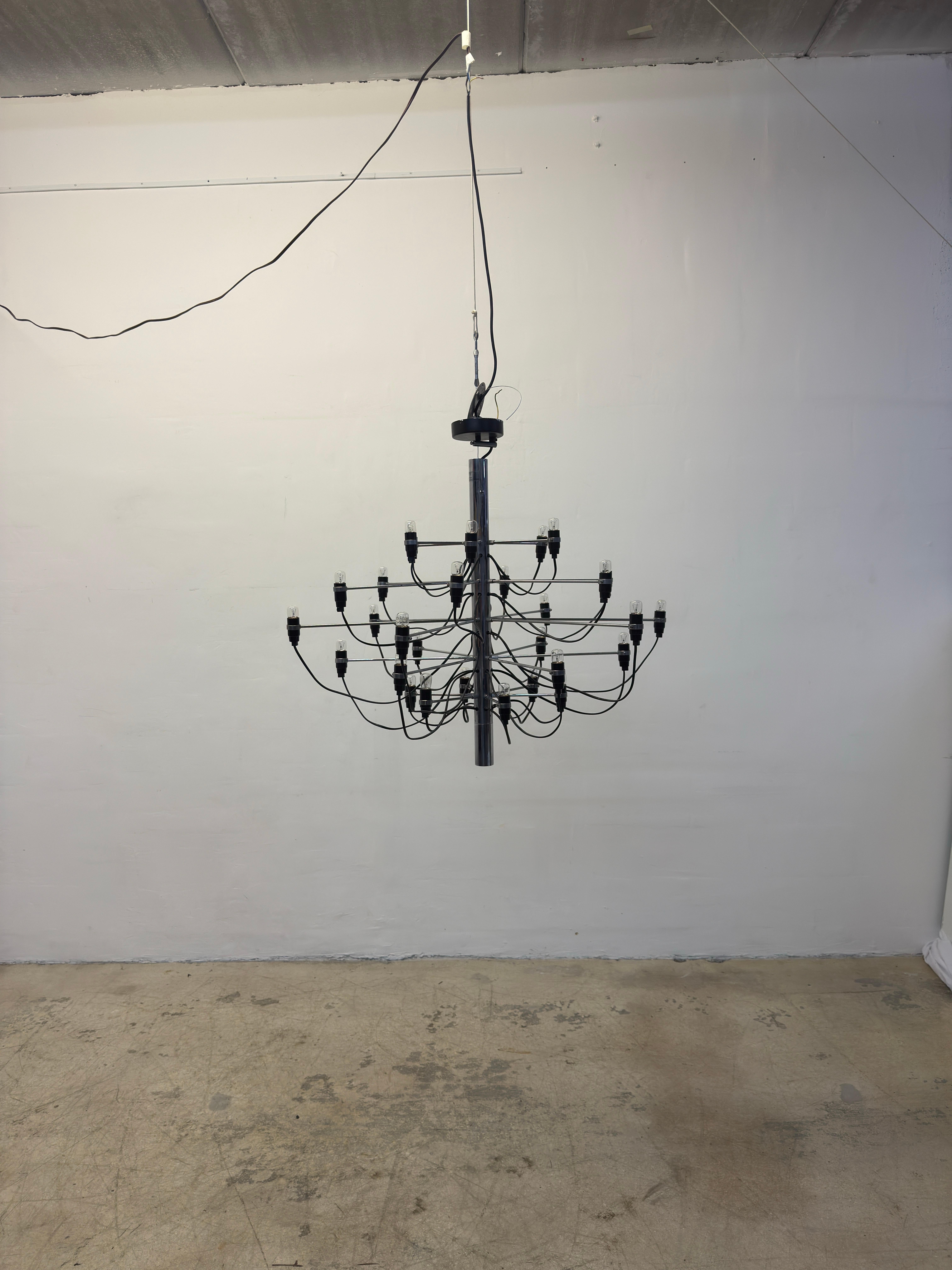 Lampadario 2097 a trenta lampadine a incandescenza originariamente progettato da Gino Sarfatti nel 1958 per Flos.  Questo pezzo è stato prodotto intorno agli anni '90 e conserva l'etichetta Flos.

Il lampadario 2097 di Flos è un design influente che