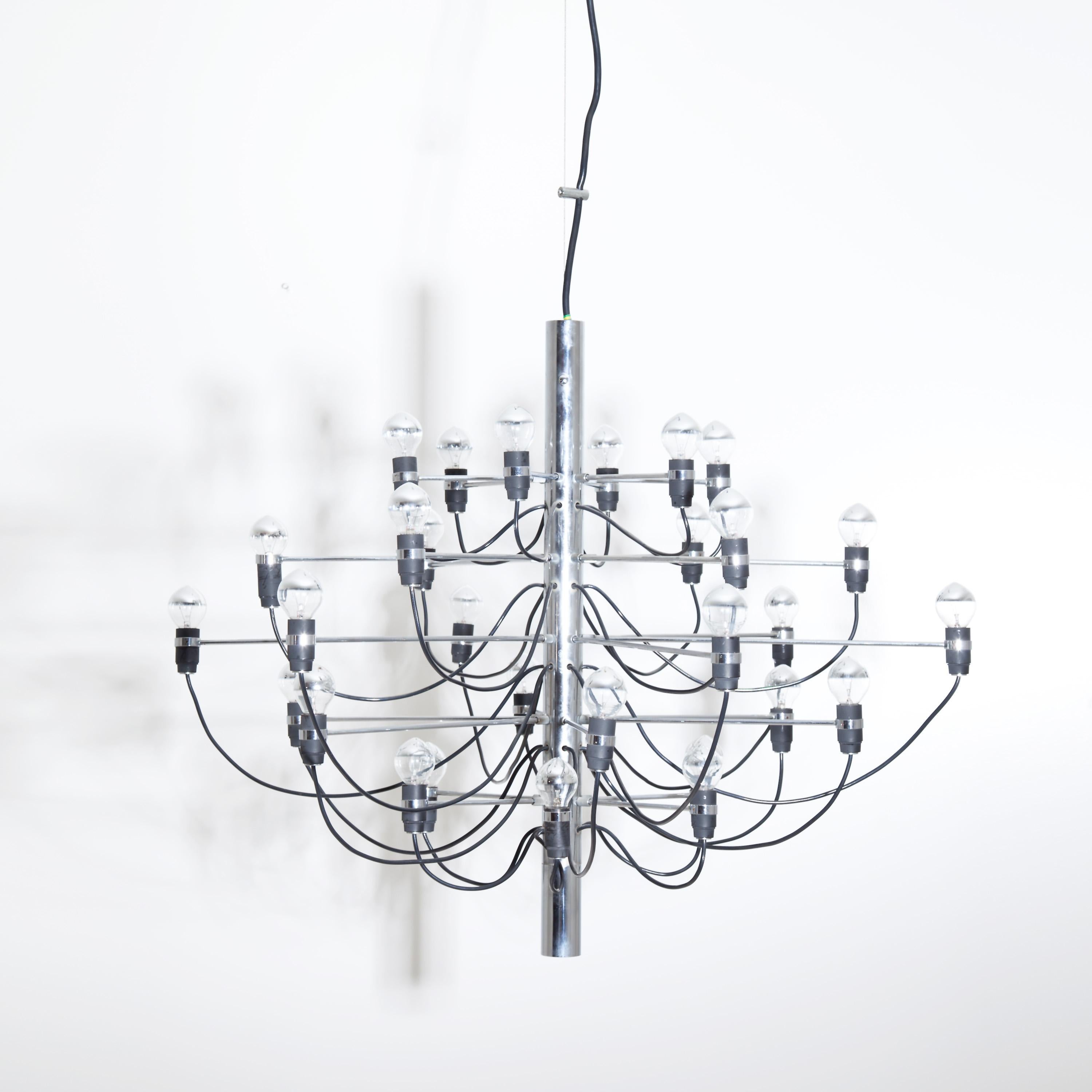 Large “2097” chandelier designed in 1958 by Gino Sarfatti and produced by Arteluce Milano. Radially arranged chandelier arms with black cables around a central cylindrical chrome-plated body. For the electrification we assume no liability and no