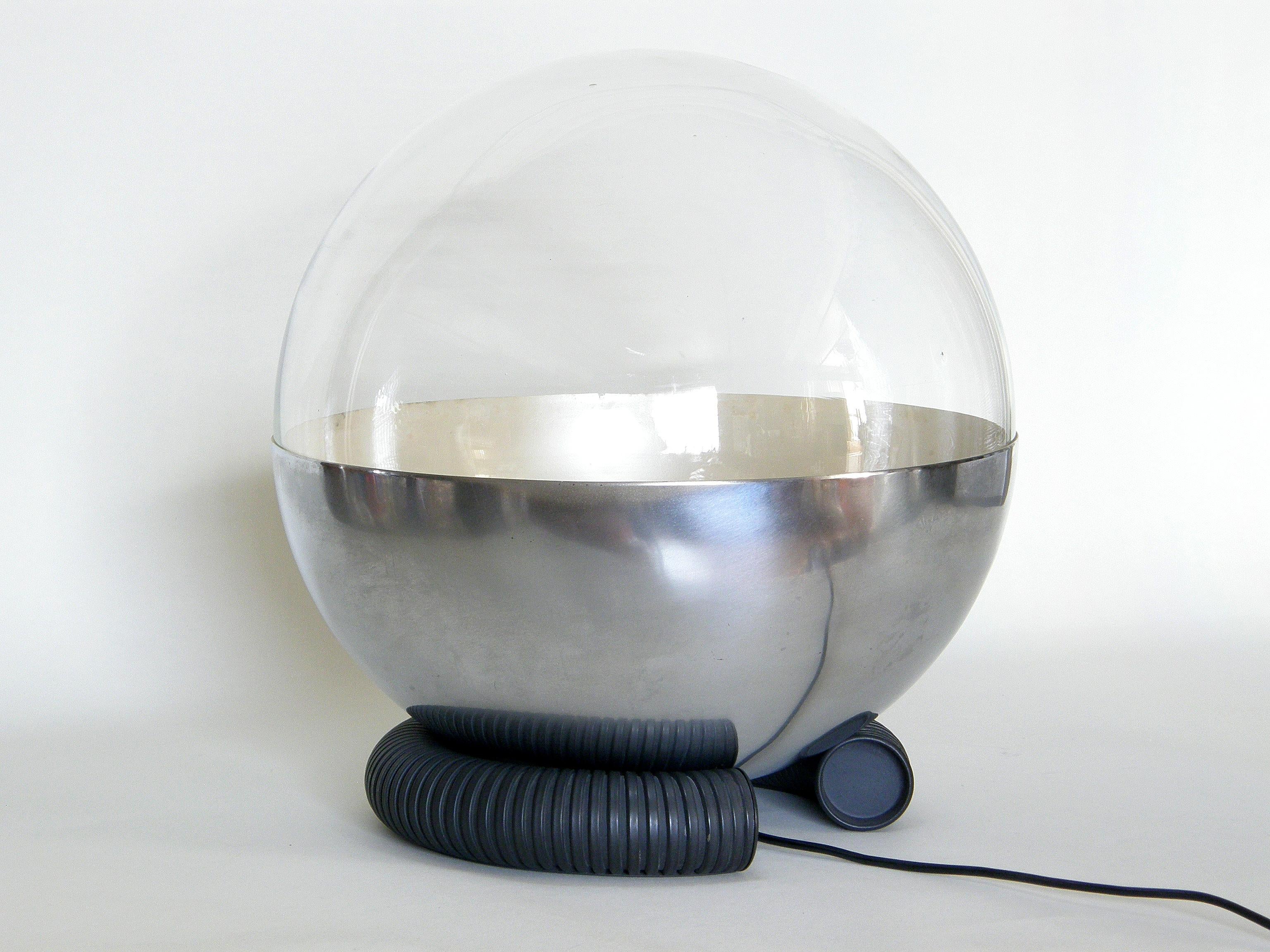 This uncommon Gino Sarfatti table lamp for Arteluce is model #598, circa 1965. The body of the lamp and the base are separate pieces. The clear glass globe is covered on one half by a metal shade with a satin nickel finish. The socket attaches to