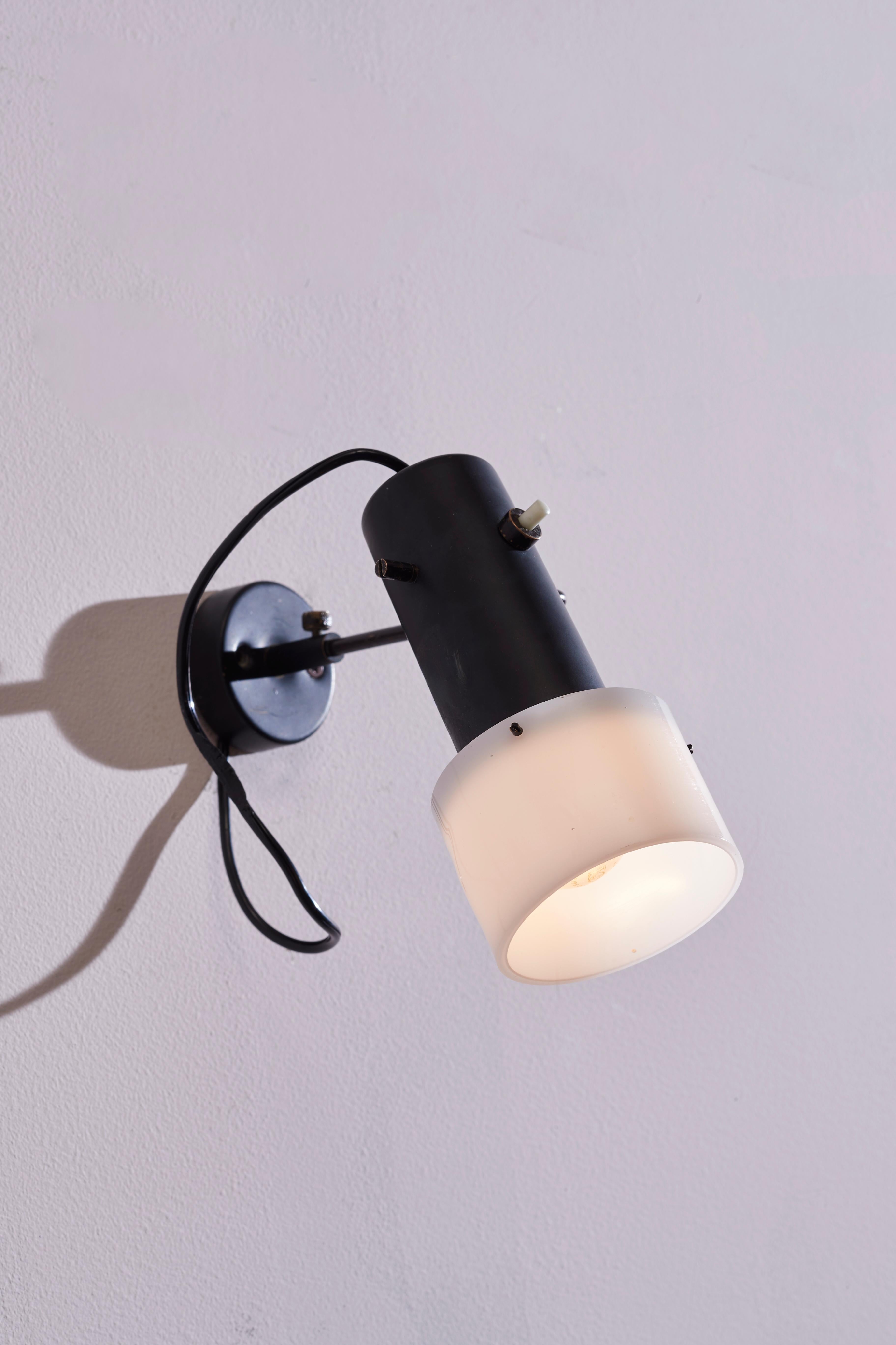 A rare and fascinating adjustable wall lamp of Model 3, designed by Gino Sarfatti and produced by Arteluce in Italy in the 1950s. Characterized by an adjustable lampshade, this lamp is made of black-painted aluminum, with a perspex cover ensuring