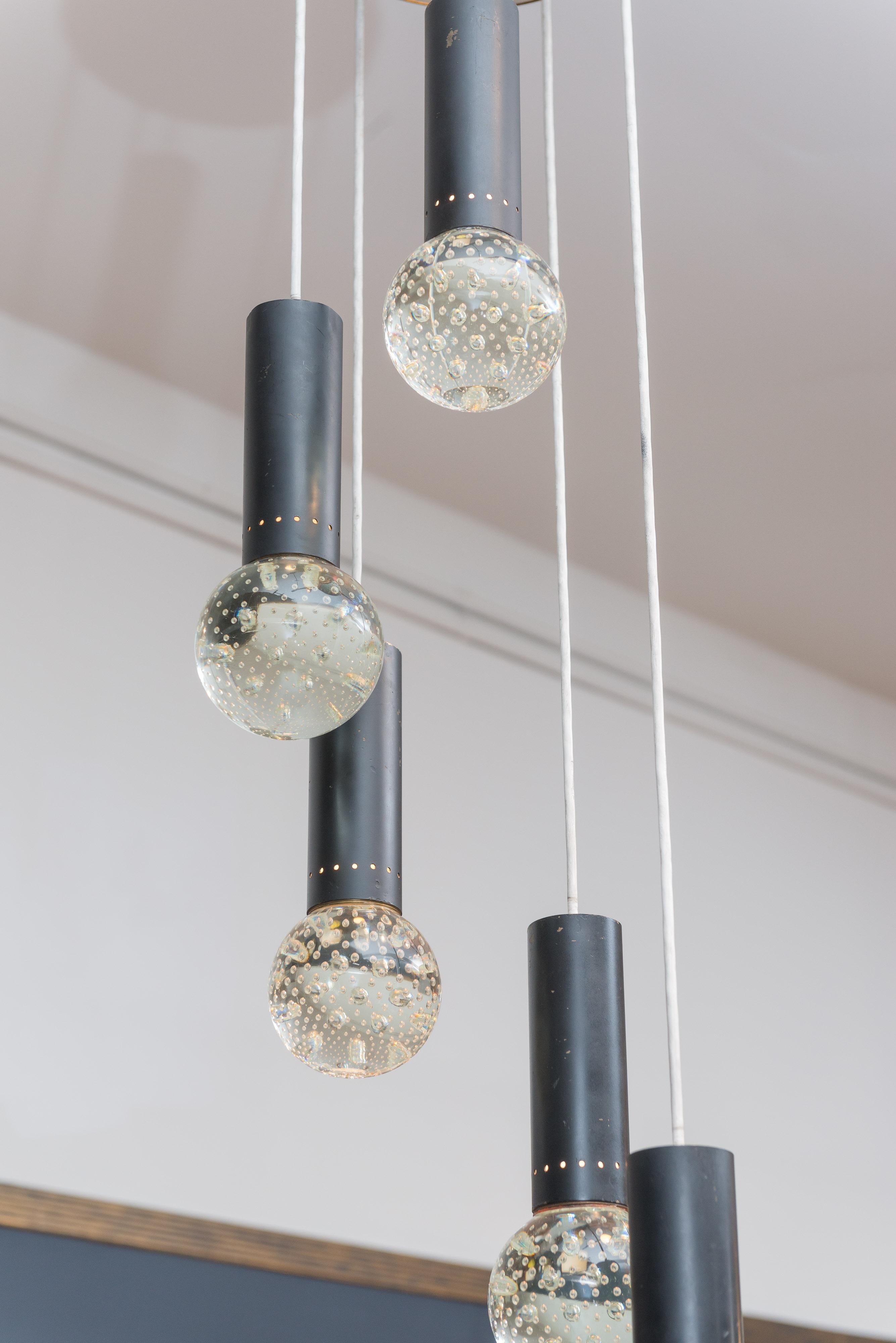 Elegant five-light chandelier designed by Gino Sarfatti and Archimede Seguso, Italy. Five solid glass pendant lights with bubble inclusions that cast off small rays of light, stunning.