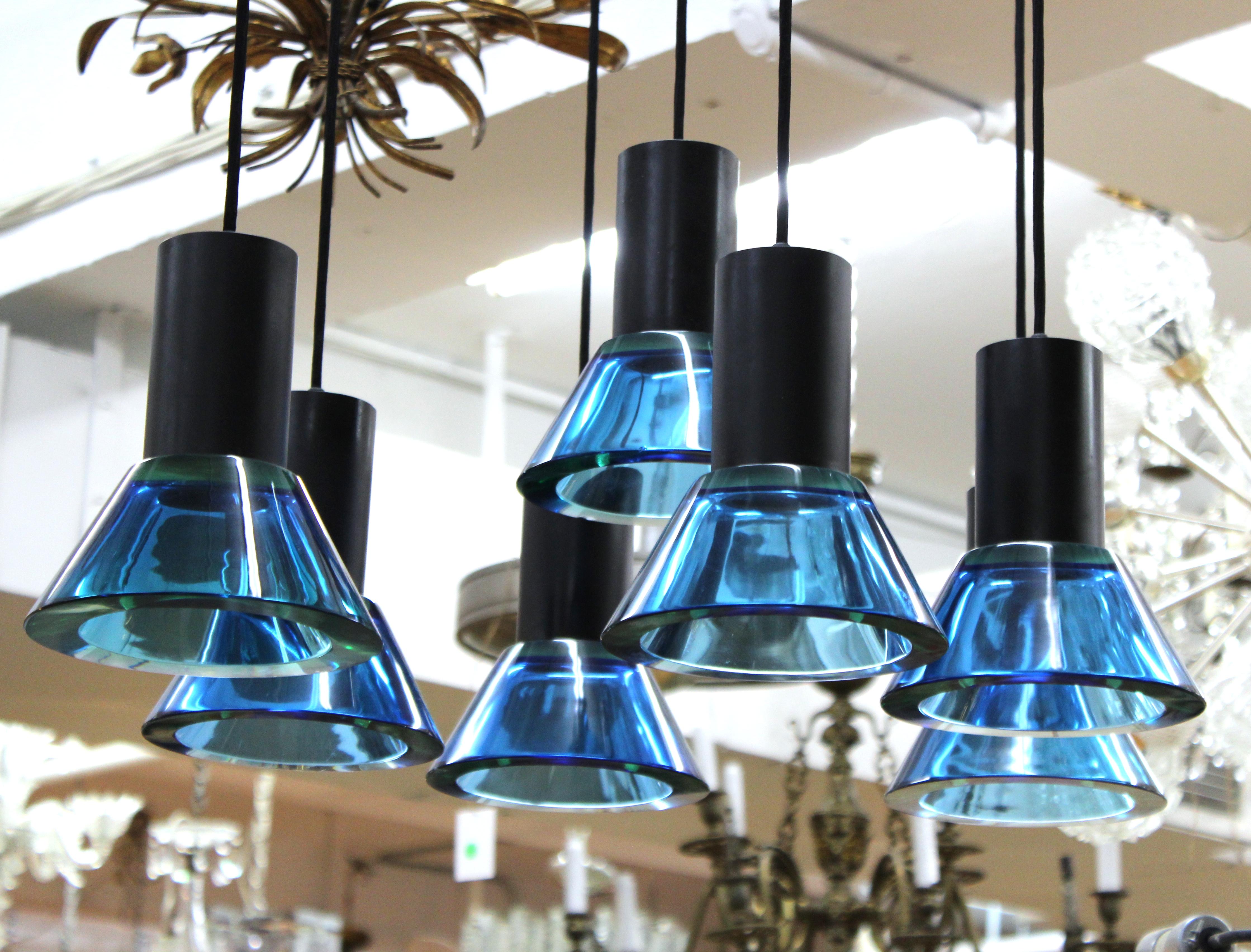Italian Modern glass pendant chandelier designed by Gino Sarfatti and Archimede Seguso. The piece has seven pendant glass shades in heavy blue glass hanging from a metal frame. In great vintage condition with age-appropriate wear and use.