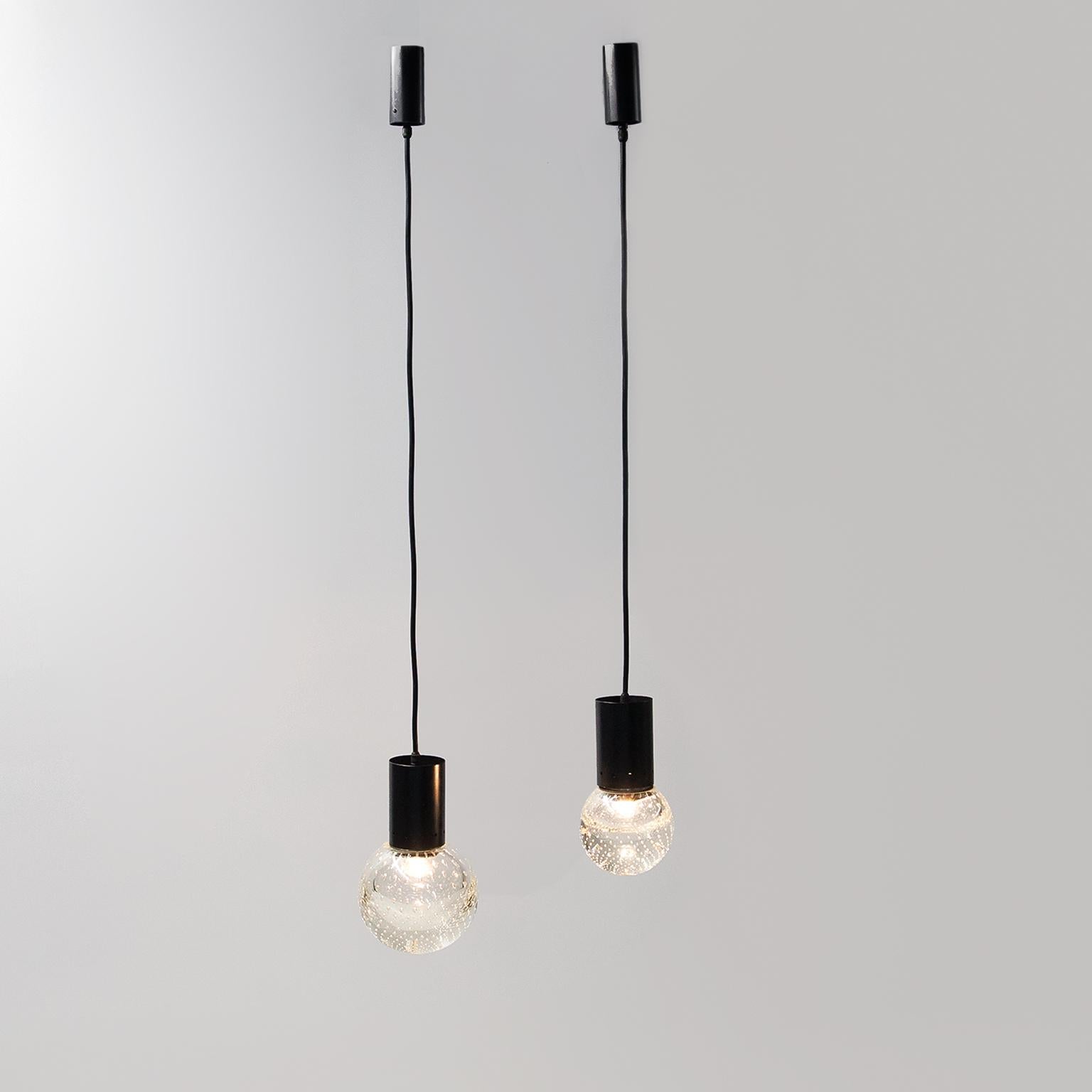 A pair of pendant lamps designed by Gino Sarfatti in collaboration with Archimede Seguso for Arteluce. The lamps consist of a black lacquered brass frame with an E14 lamp holder and hand-blown Murano glass spheres in the bubblicante technique,