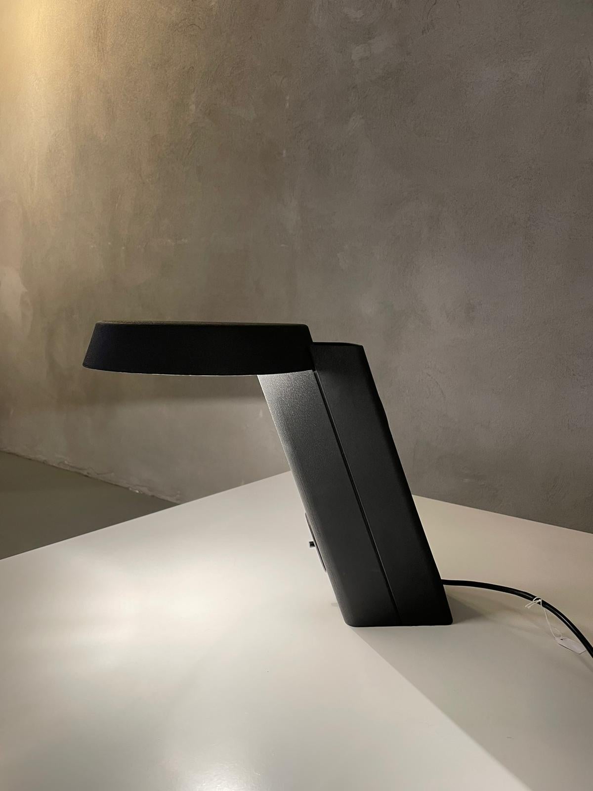 Table Lamp mod. 607 designed by Gino Sarfatti for Arteluce in Italy, 1971.
Lamp is in black painted aluminium and it's in original conditions.
Beautiful lamp with an inclined parallelepiped-shaped base that supports the round diffuser that fits