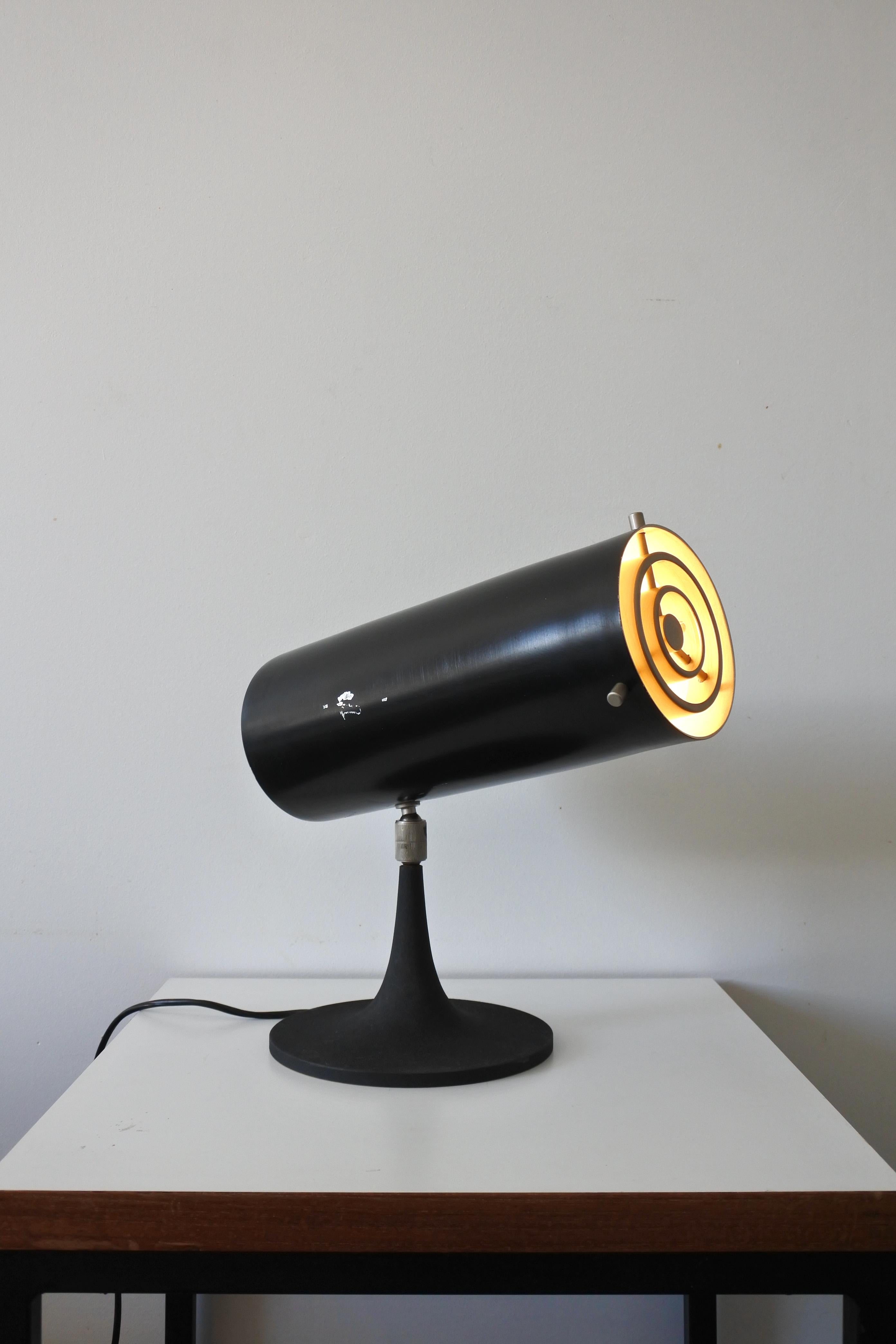 Table lamp model 569 N by Gino Sarfatti & Arteluce
Designed in 1956 and made in Italy.

Adjustable reflector in aluminium lacquered black, cast iron trumpet-shaped base lacquered in black crackle, gun-powder plated brass joint, louver and