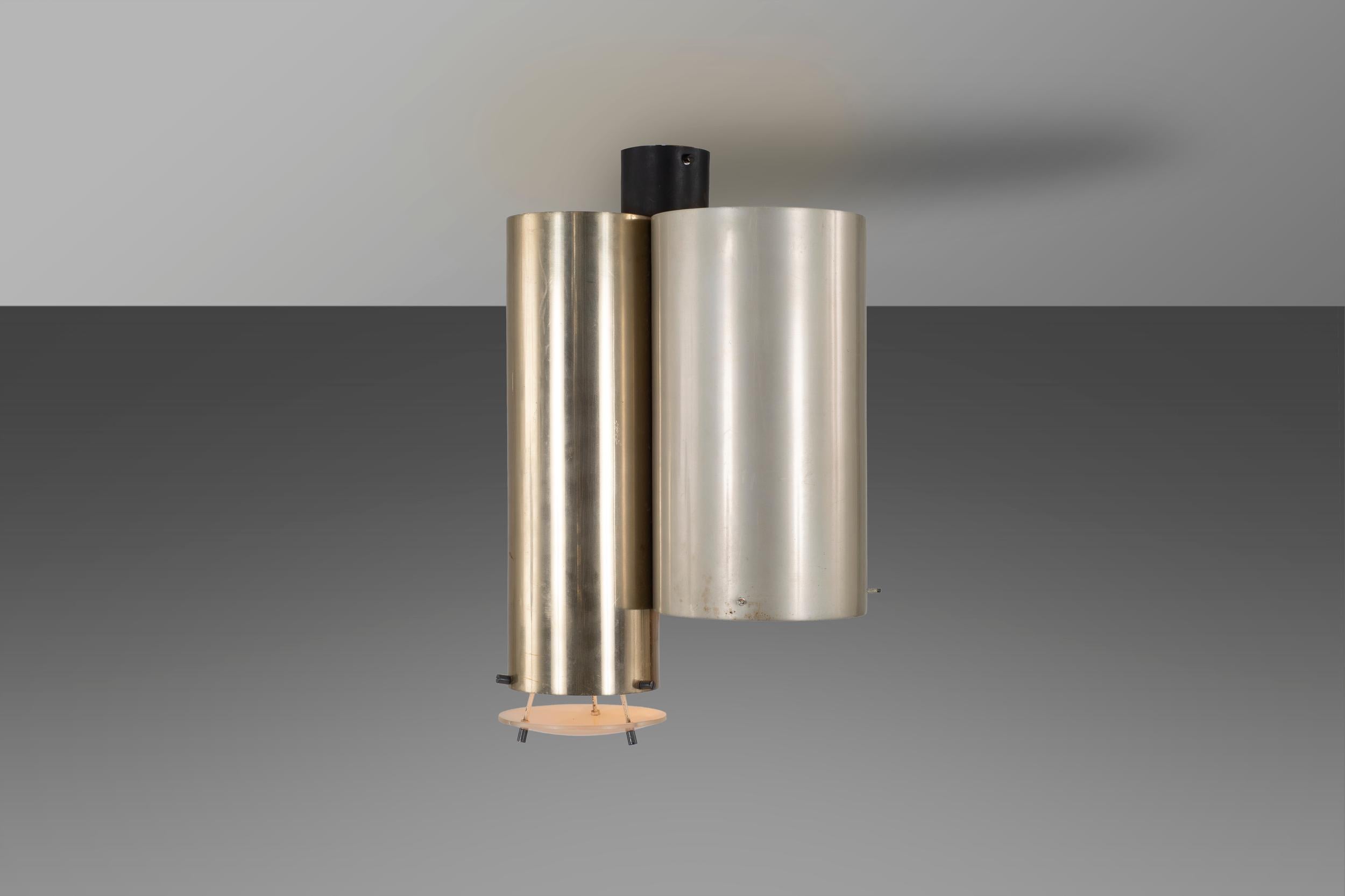 This distinctly elegant ceiling lamp is composed of a lacquered aluminium structure with color on the outside and white inside, the attention to detail can be seen in the small glass lampshade that rests under the cylinder in patinated and polished