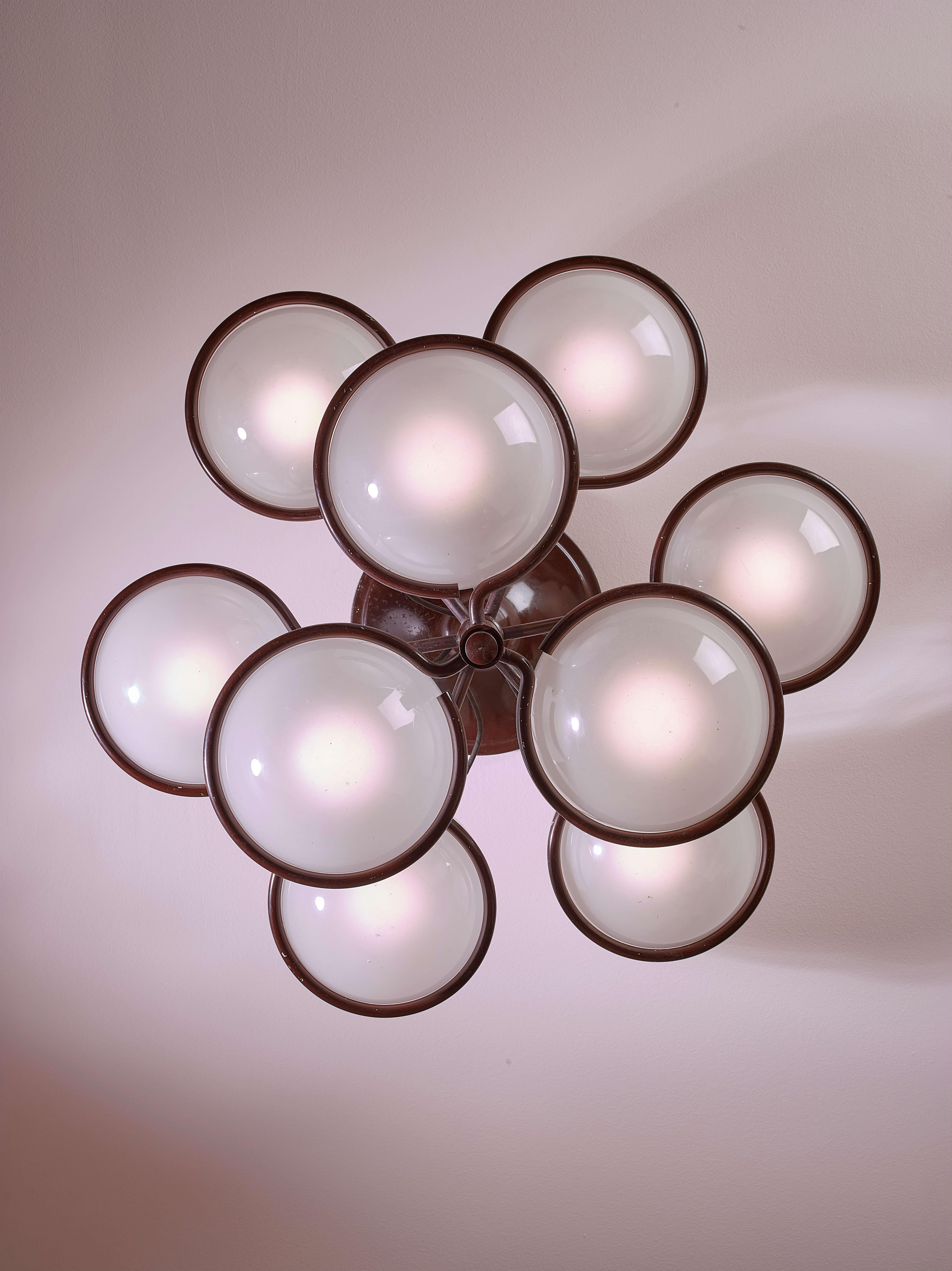 Un lampadario con nove diffusori in metallo e vetro opalino, Model 2042/9, progettato da Gino Sarfatti e prodotto da Arteluce in Italia negli anni '60.

Una sfera luminosa racchiusa in un anello di metallo, sospesa a mezz'aria, quasi senza peso.