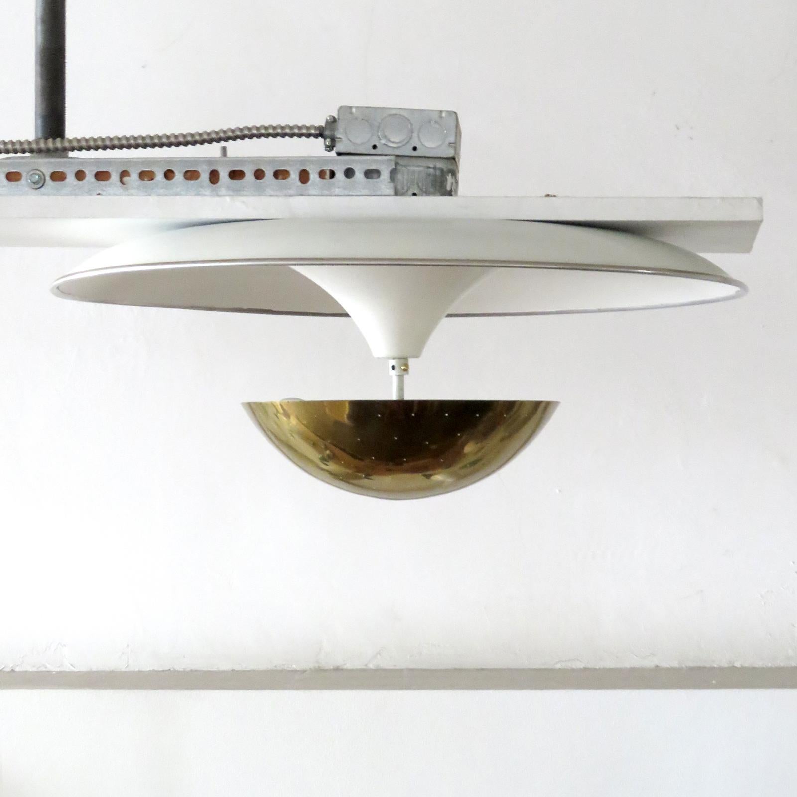 Wonderful flushmount ceiling fixture by Gino Sarfatti for Arteluce, large organically shaped ivory enameled reflector with aluminum colored rim and spherical perforated brass shade. Wired for US standards, three E27 sockets, max. Wattage 60w each,