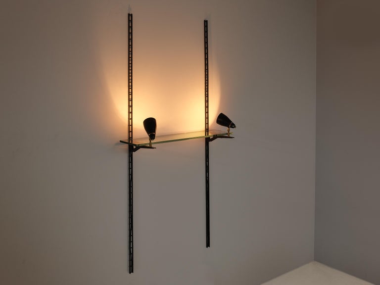 Gino Sarfatti for Arteluce, display console, metal, glass, brass, Italy, 1970s

Two vertical wall mounts in black metal hold a glass shelf. At the end of the fixtures two adjustable lamps are arranged to light up the items you want to showcase.