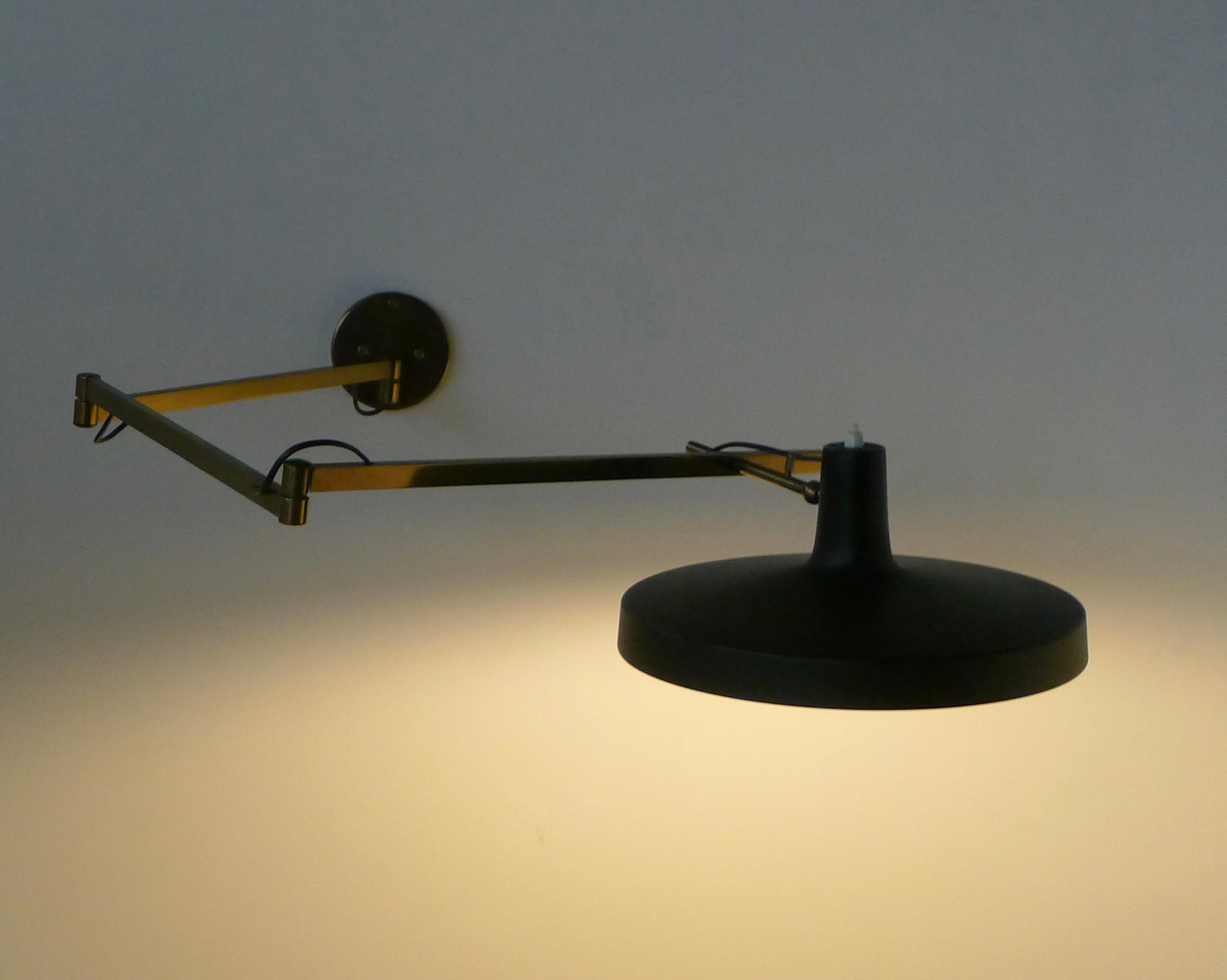 This is a very rare extendable wall light, Model 197, designed in 1953 by Gino Sarfatti and produced by Arteluce.  

Black lacquered aluminum diffuser on a brass adjustable arm.

Maximum extension 150cm, diffuser 35cm diameter.  

Bears original