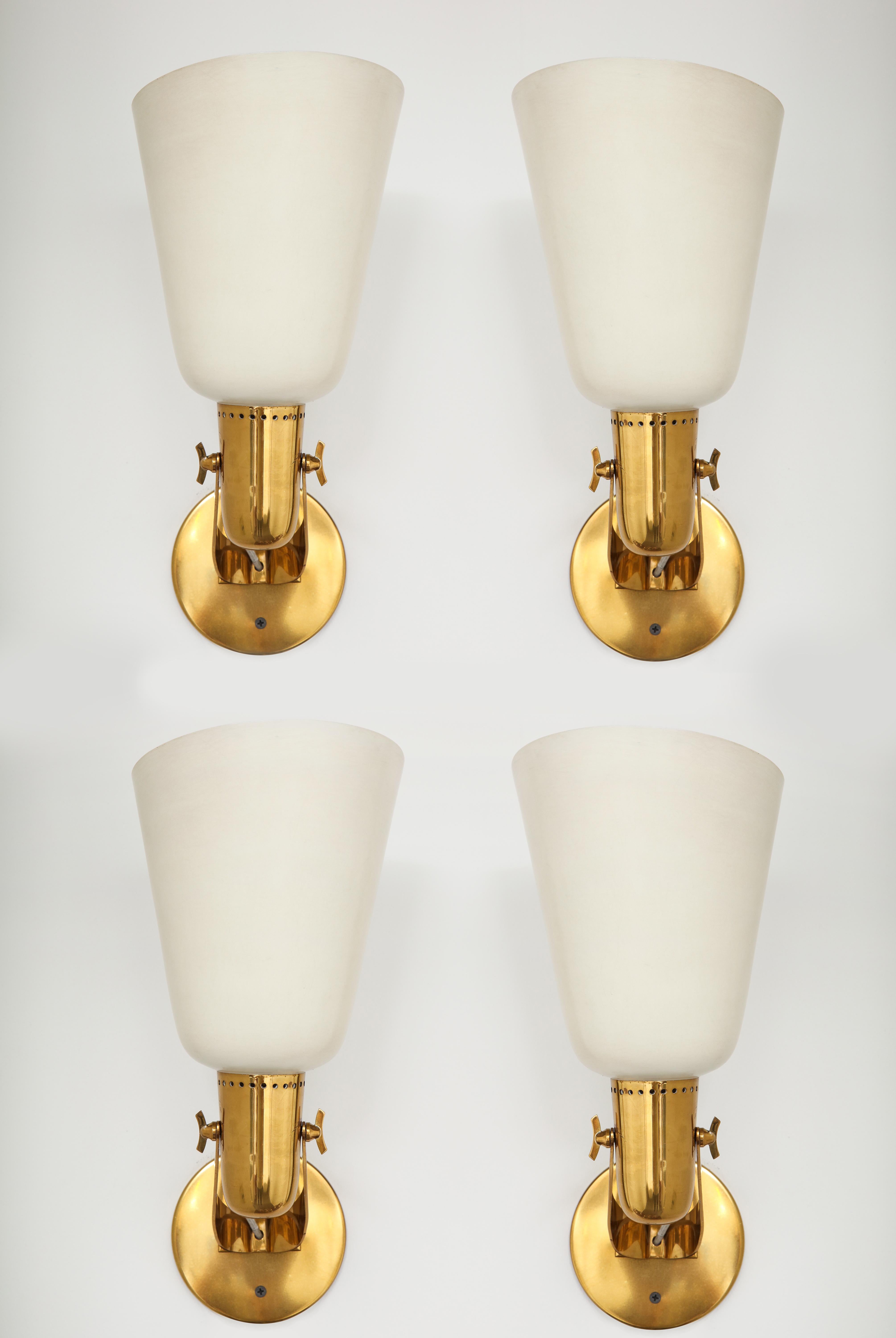 Gino Sarfatti for Arteluce very rare large set of four large sconces with cream lacquered metal shades on brass structures. These sconces are an elegant design with adjustable shades that pivot with butterfly wing nuts. In excellent original