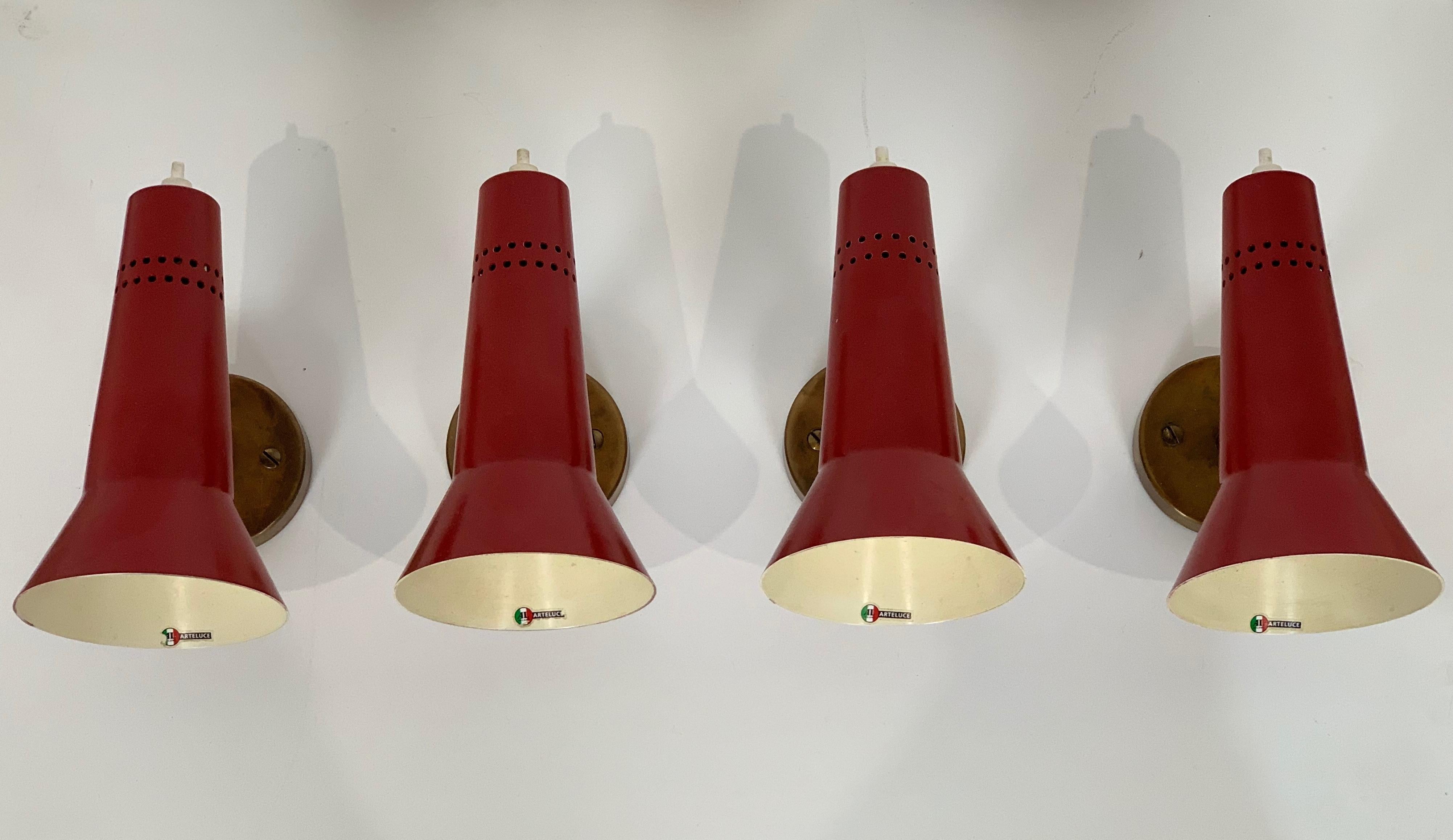Four sconces designed by Gino Sarfatti and edited by Arteluce in 1955.Adjustable reflectors in coloured lacquered aluminium. Arm, pivot and base in polished brass. Litt. 