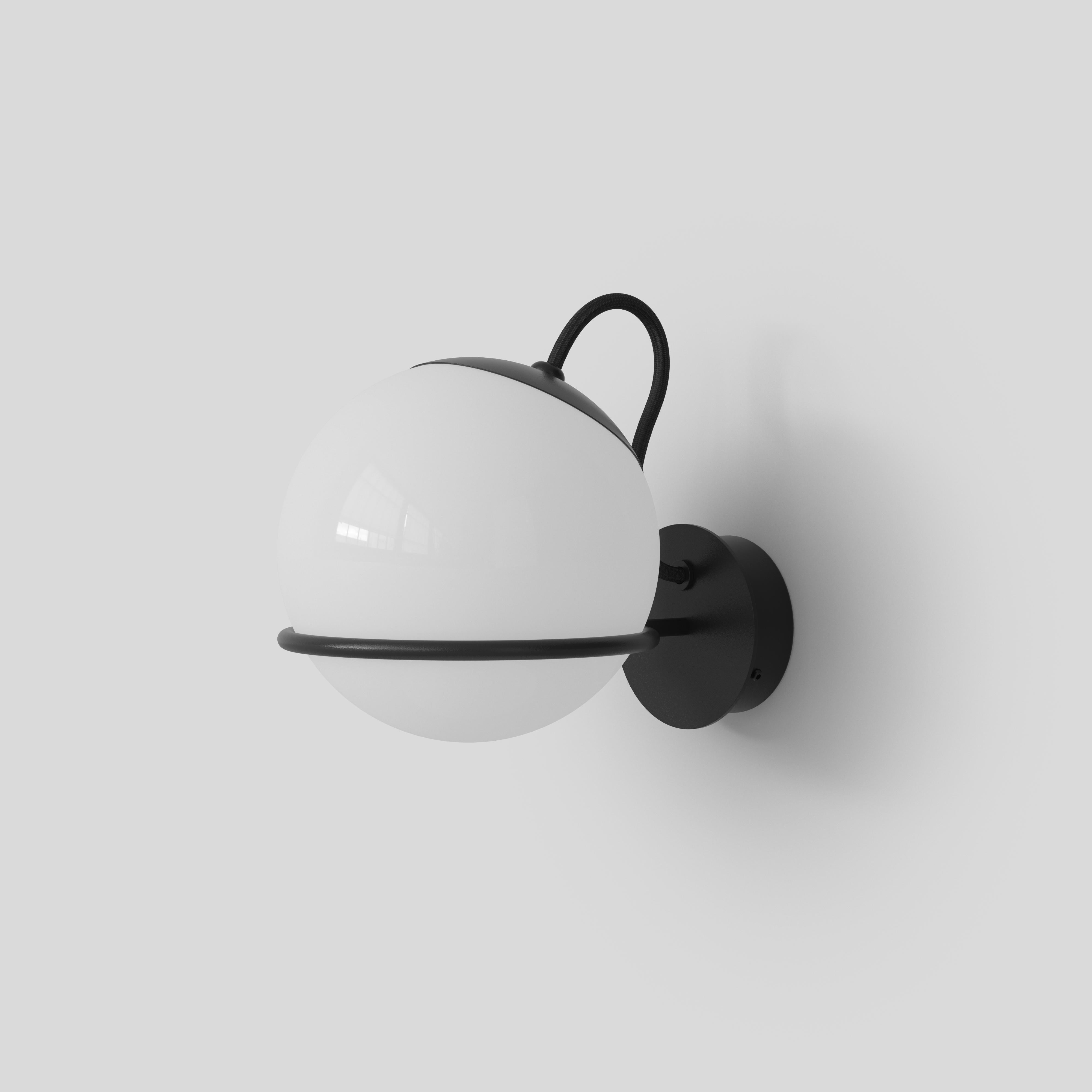 Modèle 238/1
Design par Gino Sarfatti
La sphère en verre opalin soufflé est délicatement maintenue par un anneau en aluminium peint en noir ou en champagne. L'anneau en aluminium présente une petite entaille, ce qui permet de placer la sphère vers