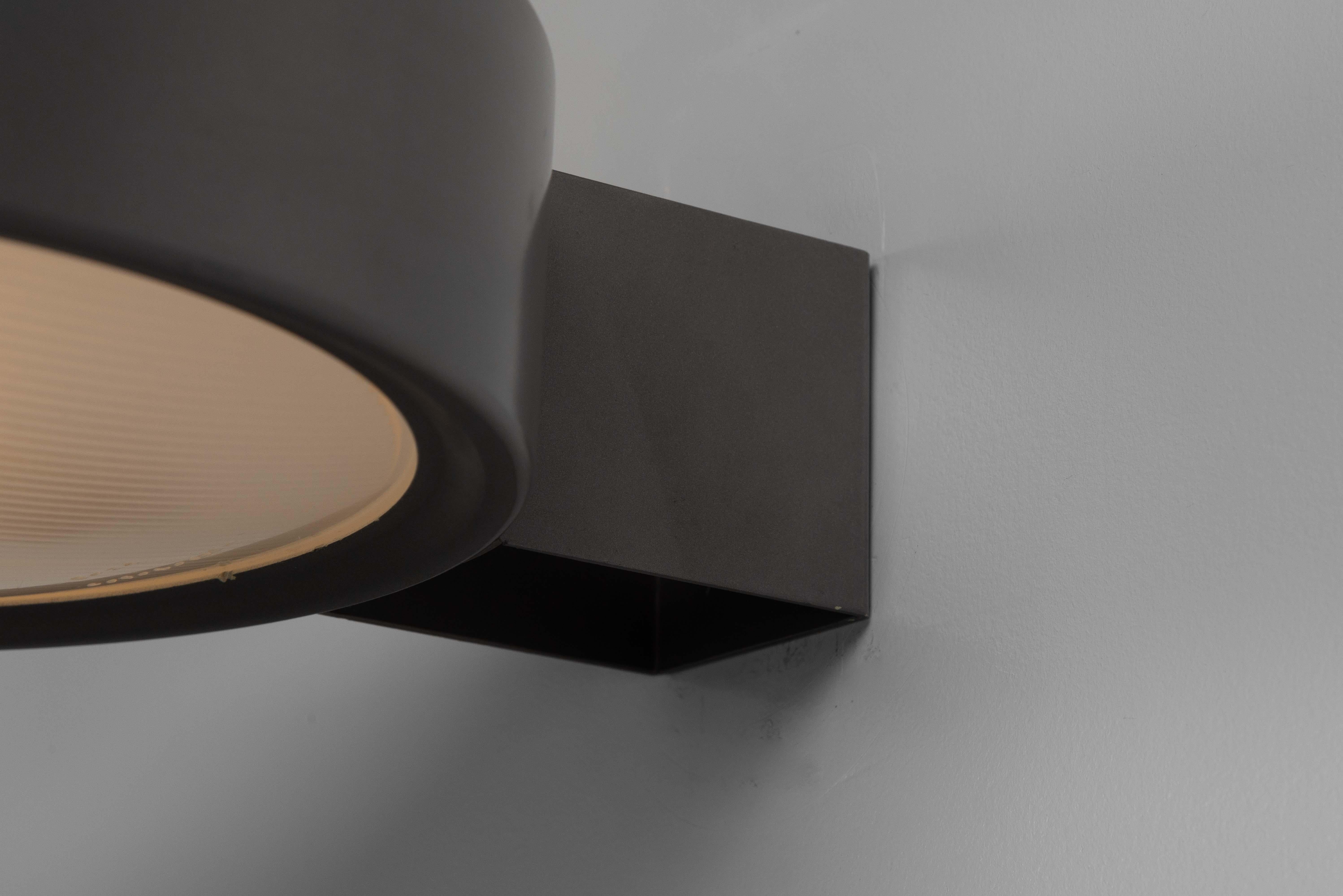 El aplique Gino Sarfatti Model 143 de Arteluce, fabricado en Italia en 1963, es una pieza distinguida del diseño moderno de mediados de siglo. Esta elegante lámpara presenta una elegante construcción de aluminio pintado en gris y metal,