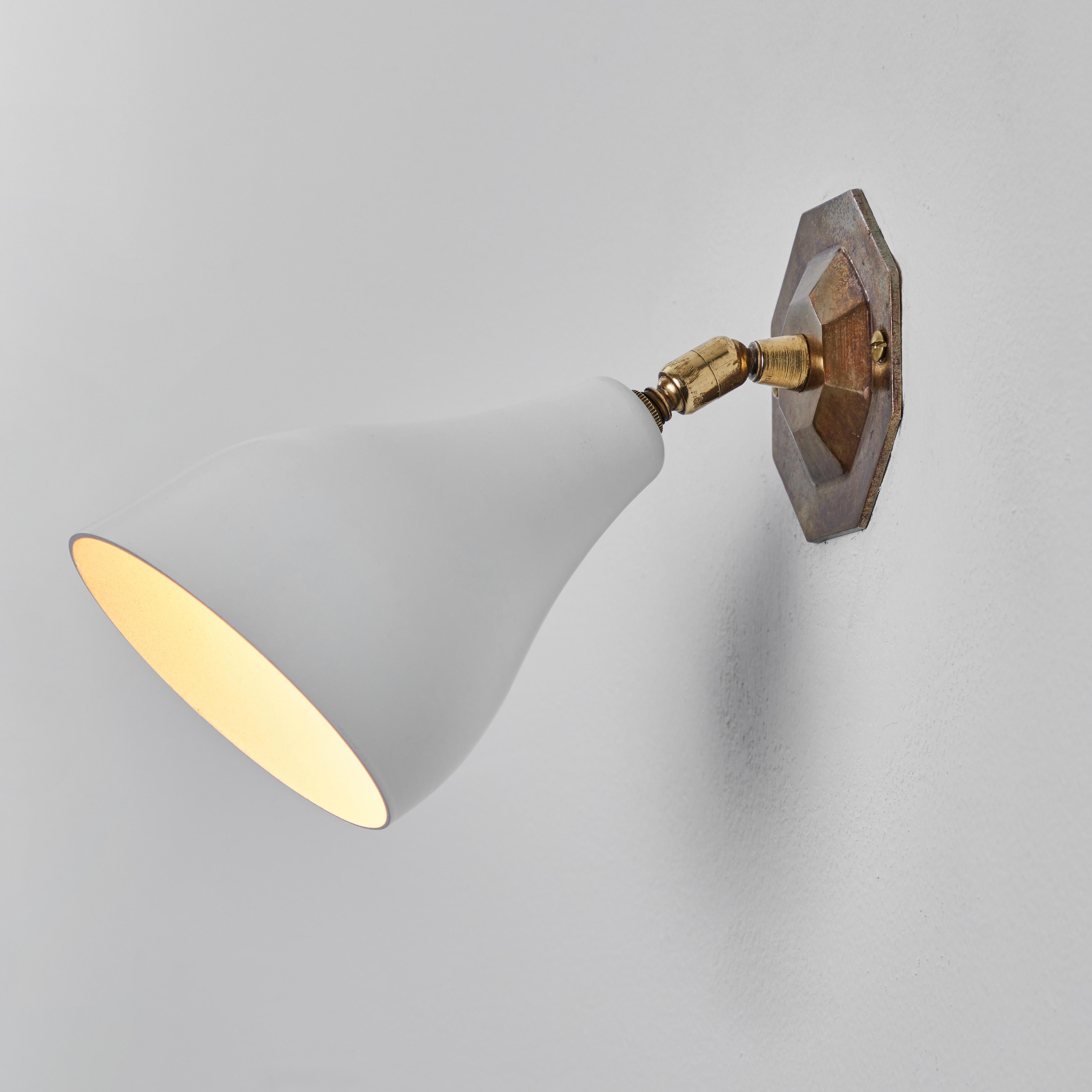 Gino Sarfatti Model #26B Wall Lamp for Arteluce. Executed in white painted aluminum with a geometric patinated brass backplate. Double ball jointed arm allows flexible shade adjustments and multiple configurations. The simplicity of Sarfatti's