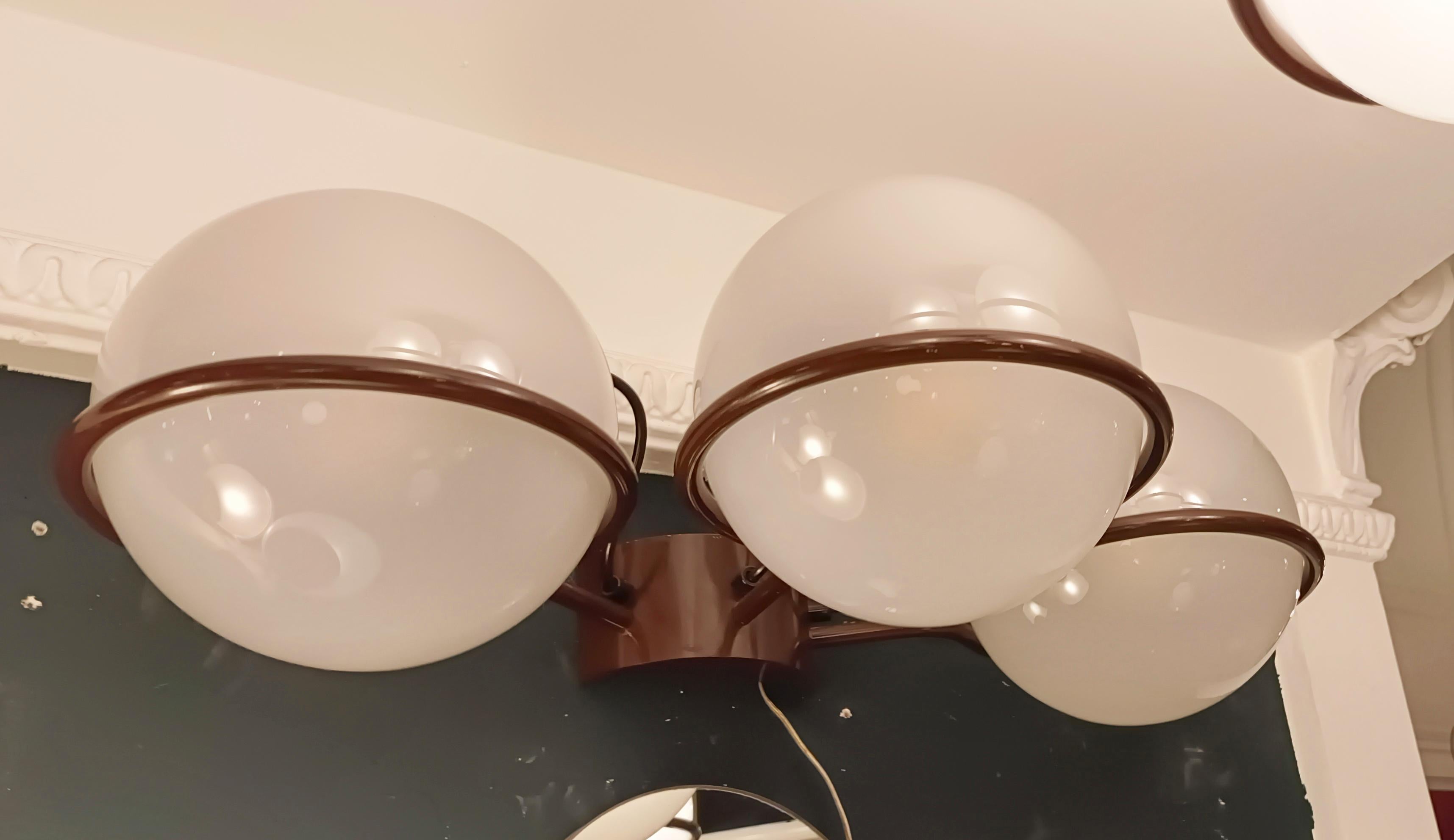Splendida lampada da parete a tre luci modello 238/3 di Gino Sarfatti for Arteluce 1960. In eccellenti condizioni originali. La piastra da parete in ottone con bracci piegati a formare cerchi ospita globi di vetro traslucido con fusibili cilindrici