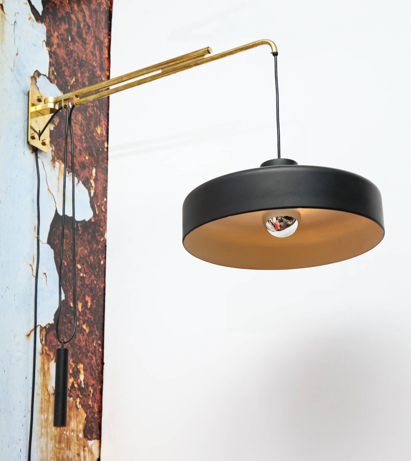 Adjustable sconce #149/N by Gino Sarfatti for Arteluce. Brass wall mount and extended arm. Black painted metal shade and counter weight. Height can be adjusted and arm moves from side to side. Manufacturers label on inside of shade.