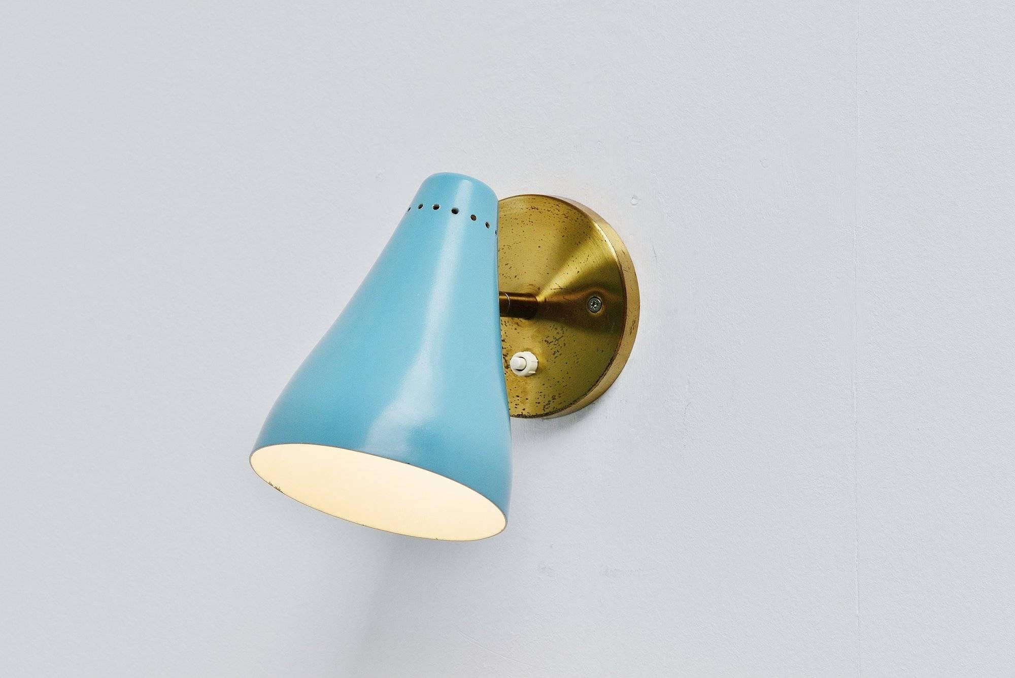 Early sconce model 16c designed by Gino Sarfatti, manufactured by Arteluce, Italy, 1948-1950. This early wall lamp has a brass wall plate and a blue painted shade with die cut dot pattern at the top of the shade. The lamp is unmarked but written