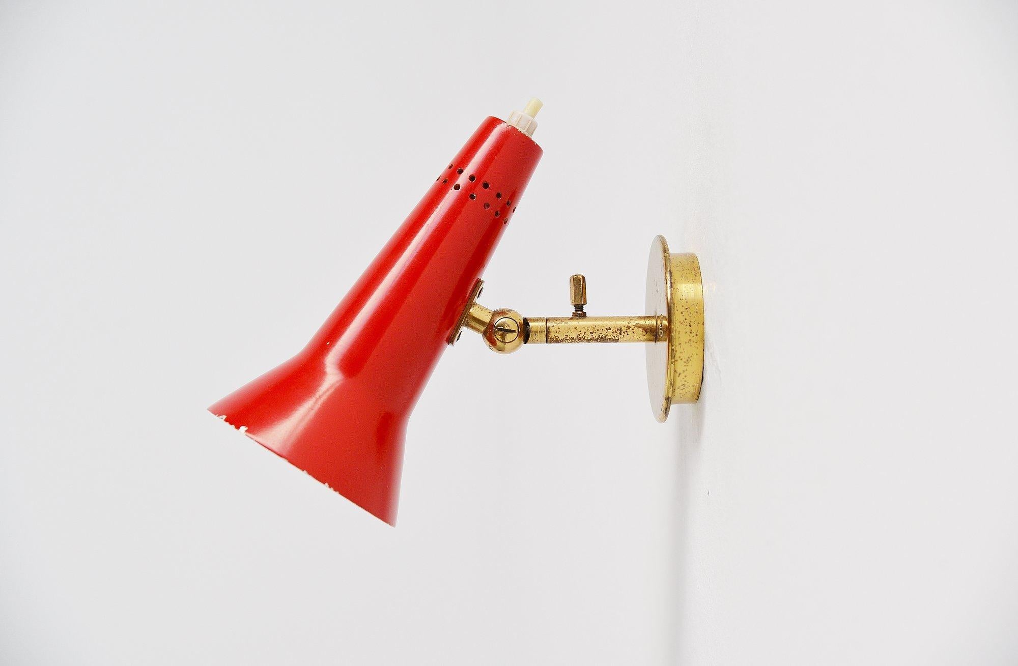 Early small sconce model 21 designed by Gino Sarfatti, manufactured by Arteluce, Italy 1955. This early wall lamp has a brass wall plate and a red painted shade with die cut dot pattern at the top of the shade. The lamp is marked with Arteluce