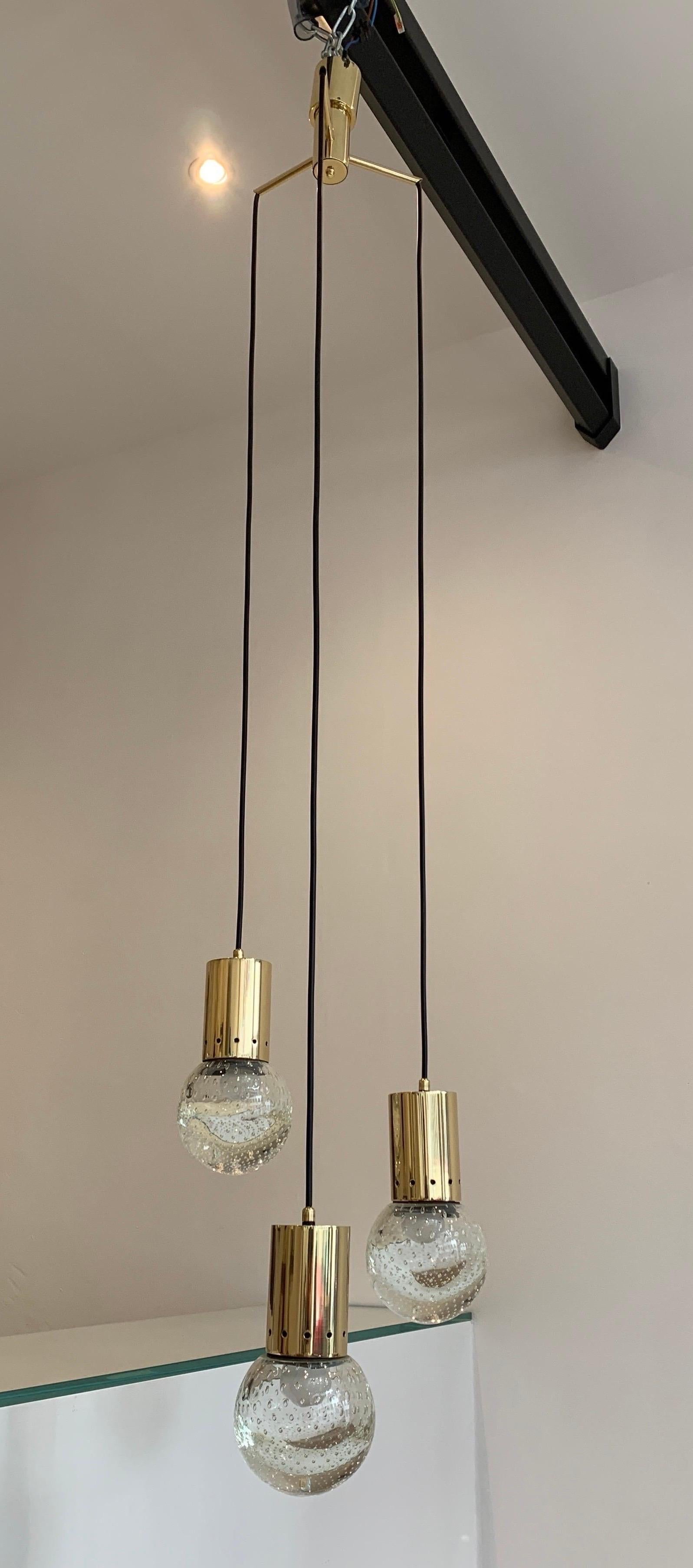 The pendant is designed by Gino Sarfatti. He was one of the most avant-gardiste light designer in the twentieth century in Italy. The pendant combines his design with glass spheres decorated with internal bubbles. The spheres were realized by Seguso