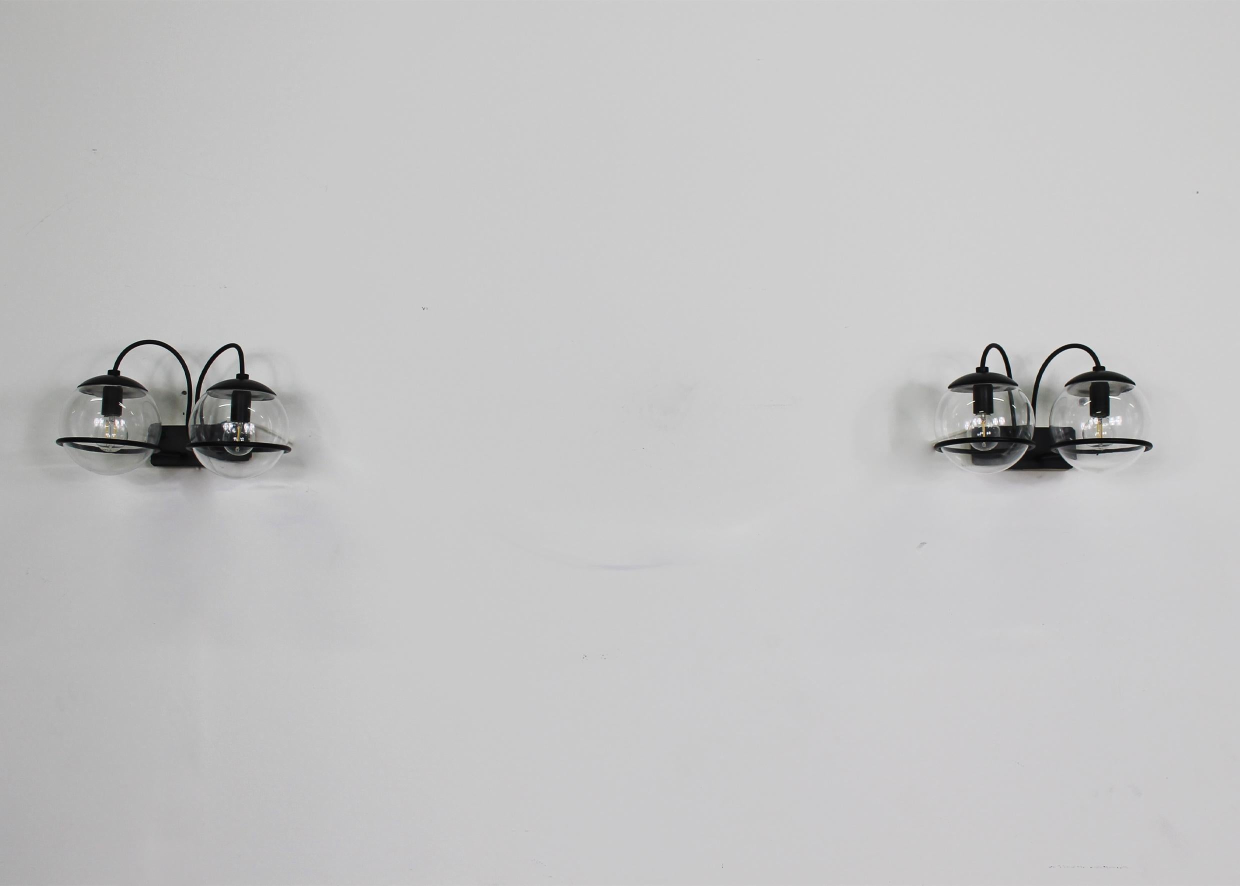 Set di due lampade da parete modello 238/2 con supporti in metallo laccato nero, paralumi in vetro soffiato e alluminio smaltato nero, disegnate da Gino Sarfatti e prodotte da Arteluce negli anni Sessanta.

Gino Sarfatti è nato a Venezia nel