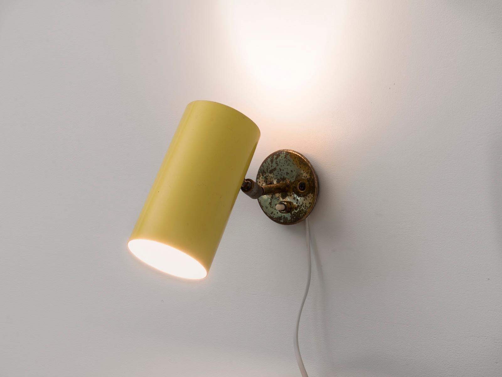 This fully directable wall light was designed by Italian lighting master Gino Sarfatti for his own company Arteluce in the 1950s. This model was mostly manufactured in black or cream white color, this yellow version is rarer (and documented). The