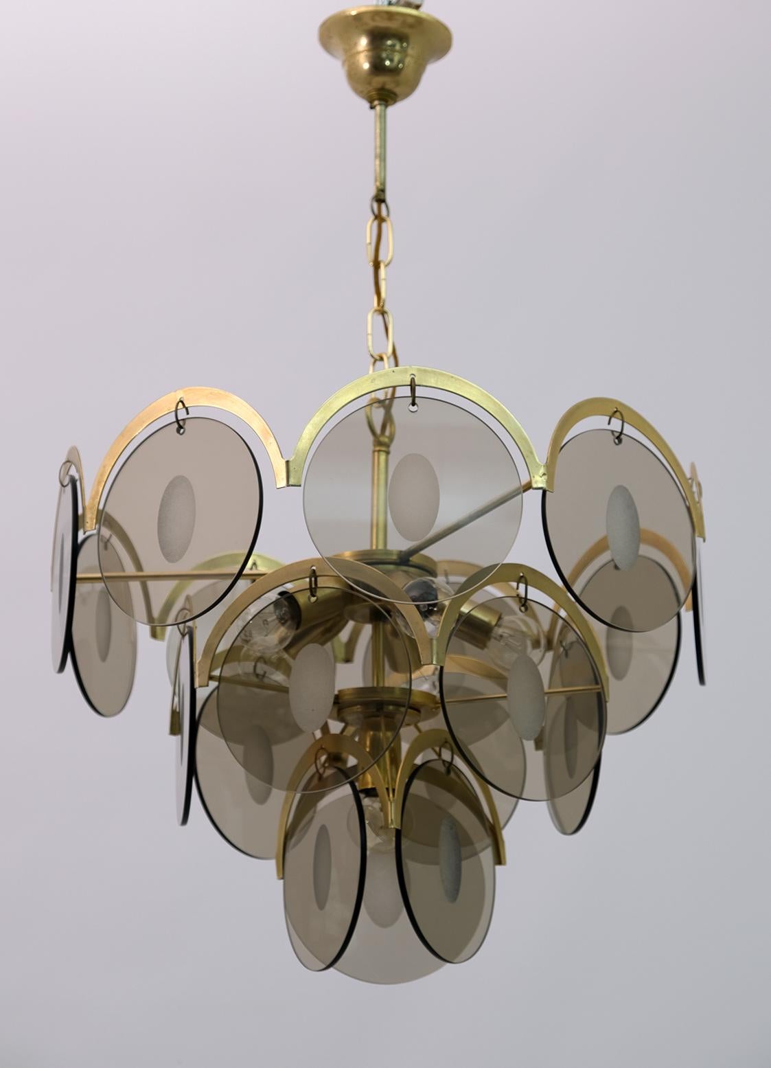 This 6-light chandelier, golden metal structure with 18 discs with a diameter of 14.5 cm, the discs were made of smoked bronzed glass and central grinding.
