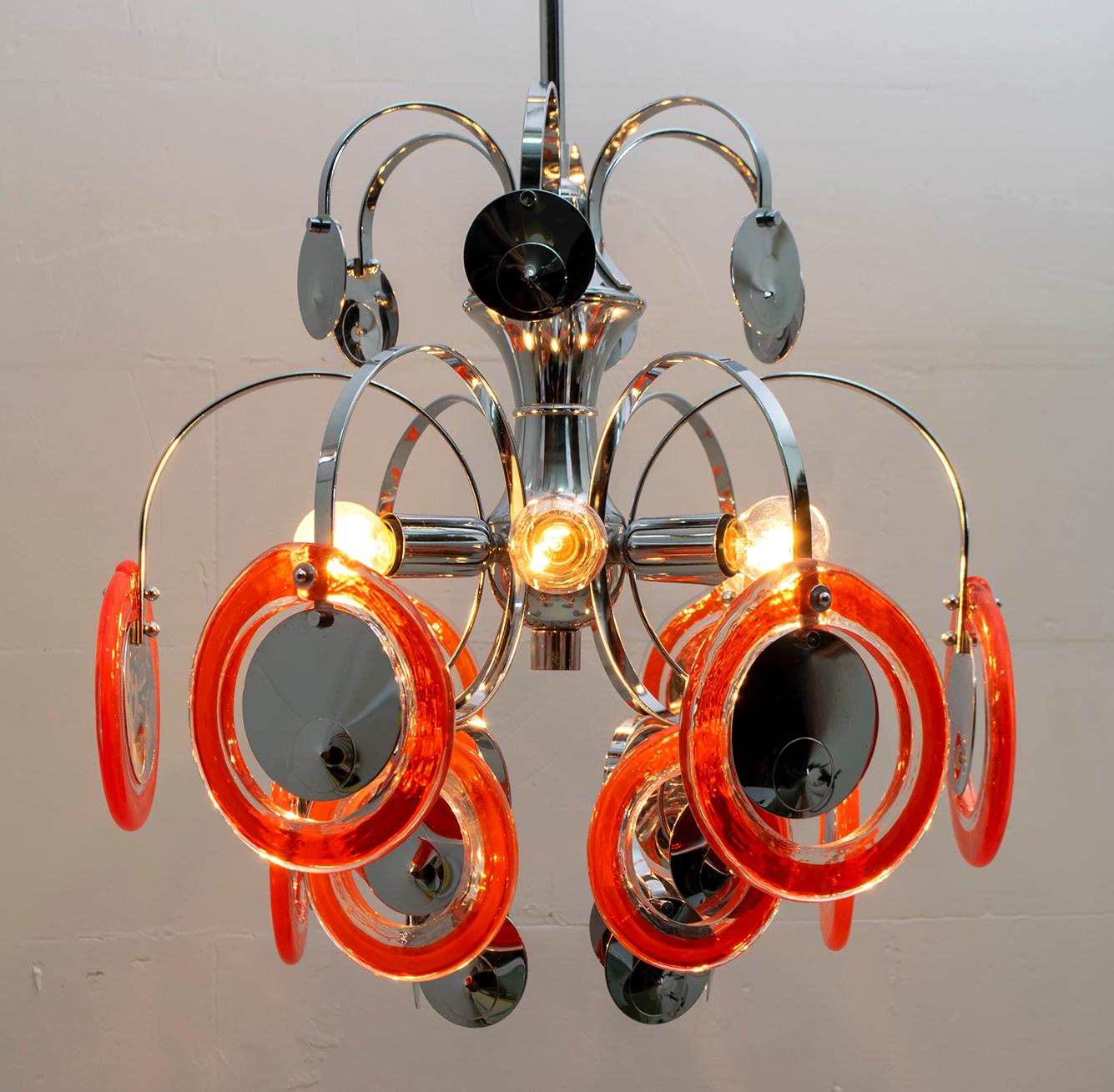 This 6-light chandelier has a chromed metal frame with 12 red Murano glass disks with a diameter of 13.5 cm and a diameter of 11 cm.

Vistosi is an Italian company, active in the field of decorative blown glass lighting, based in the province of