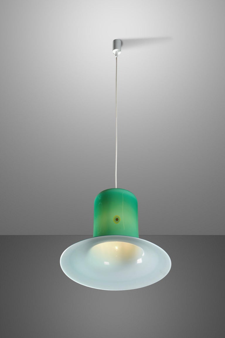 This beautiful pendant was designed by Gino Vistosi and manufactured by the famous Italian glasswork Vistosi in Murano in the 1960s.
It is made from a double Murano glass layer (“incamiciato”) in white and green colors. A big yellow, green and red