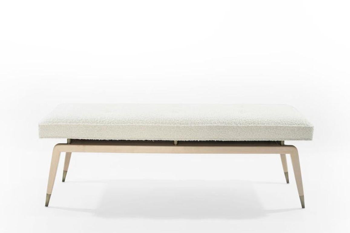 Discover The Gio Bench by Stamford Modern: Inspired by the iconic Gio Ponti, this bench seamlessly marries classic elegance with modern functionality. Its distinctive angled legs, adorned with metal sabots and risers, support a sumptuous upholstered