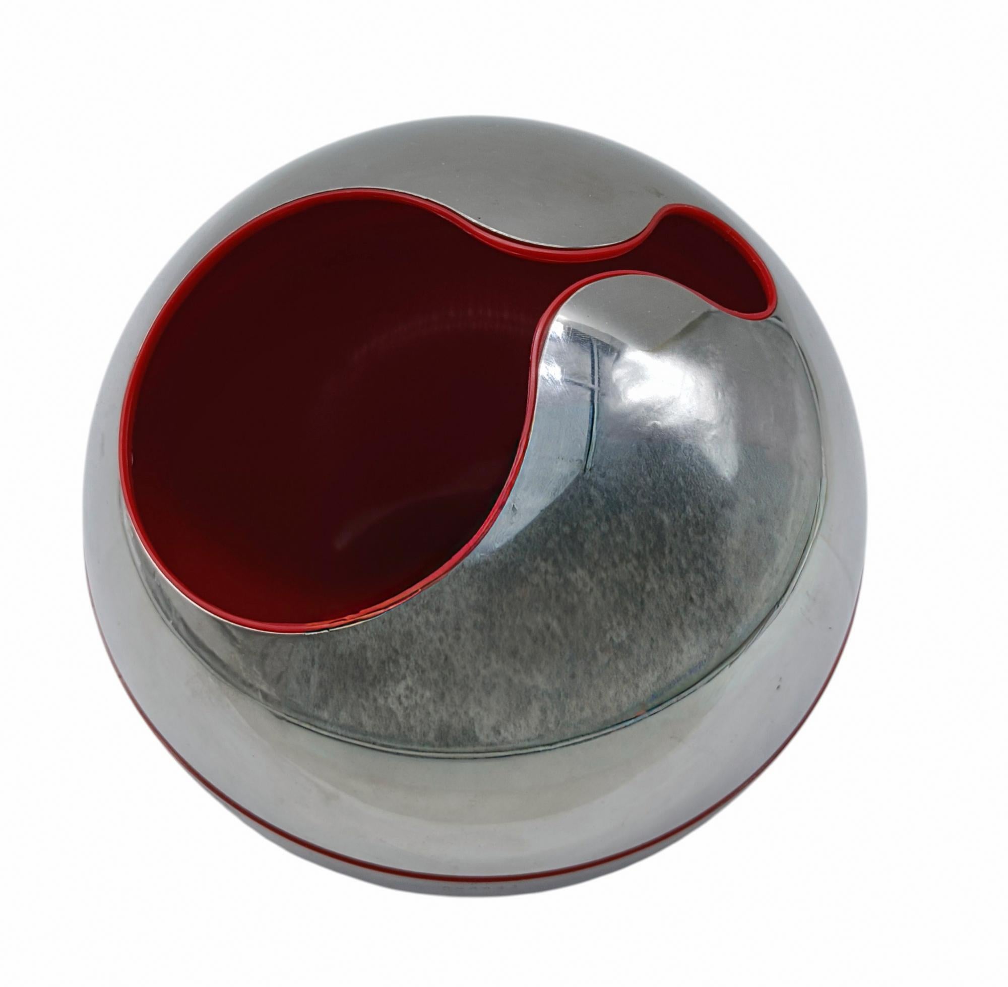 Magnifique sculpture/vase conçu par Gio' Pomodoro pour la firme Alessi D'Apres en acier chromé avec découpe et intérieur en plastique rouge, marqué 