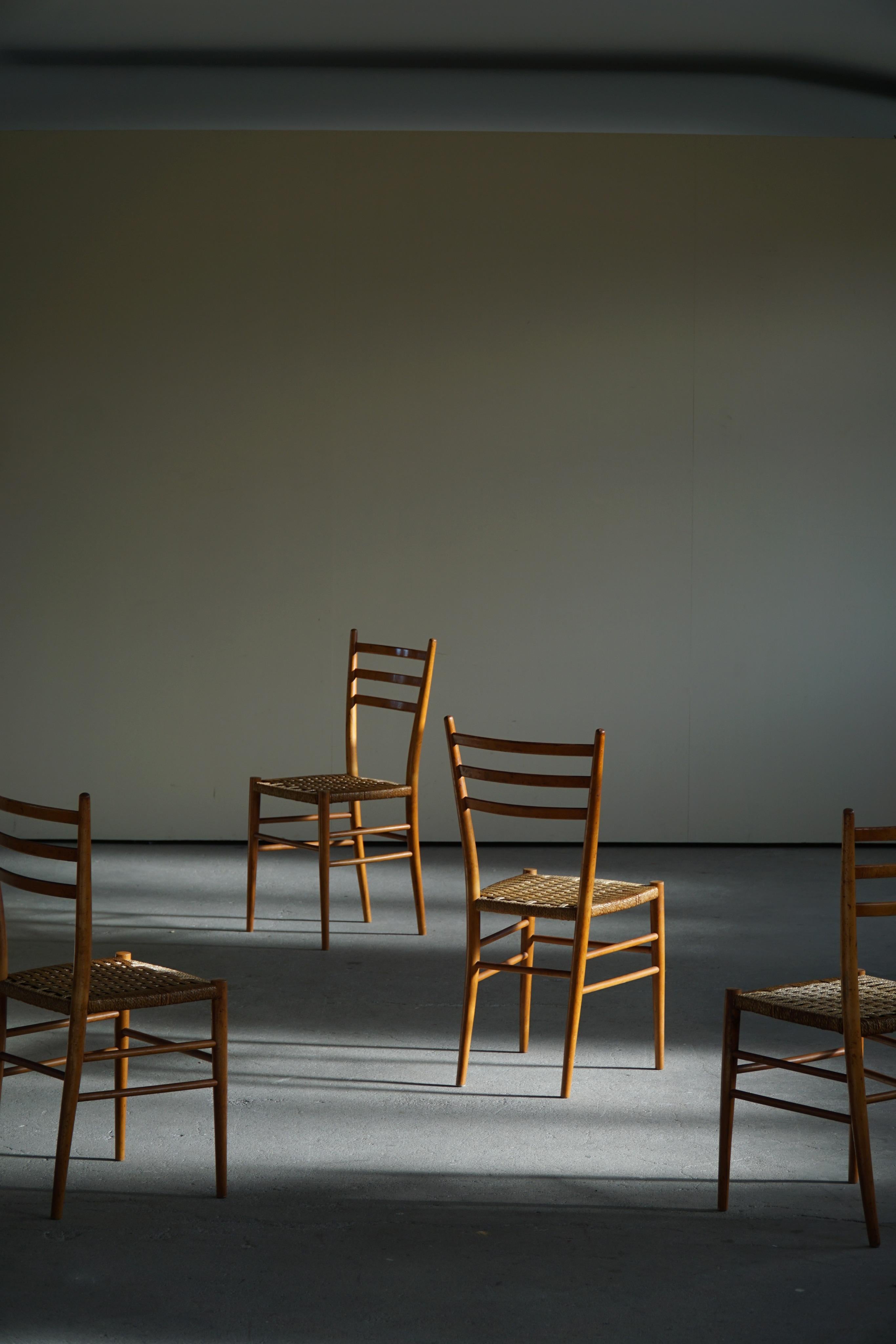 A classic set of 4 minimalistic dining chairs made in solid beech and wicker. Made in the manner of Gio Ponti in the 1960s. The wicker seats are nicely patinated, the wooden frame with traces of wear.

These Italian vintage chairs will complement
