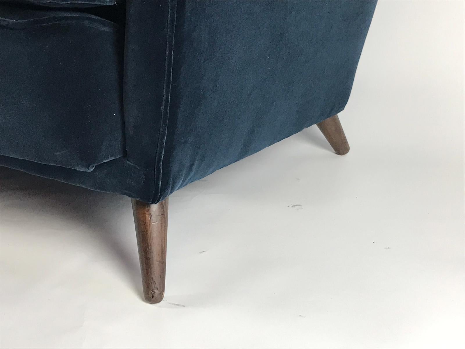 A fabulous and elegant 3-seat winged back sofa designed by Gio Ponti newly upholstered in navy velvet. The sofa is designed with beautiful lines with indented sides and a buttoned back and is standing on its original walnut feet.