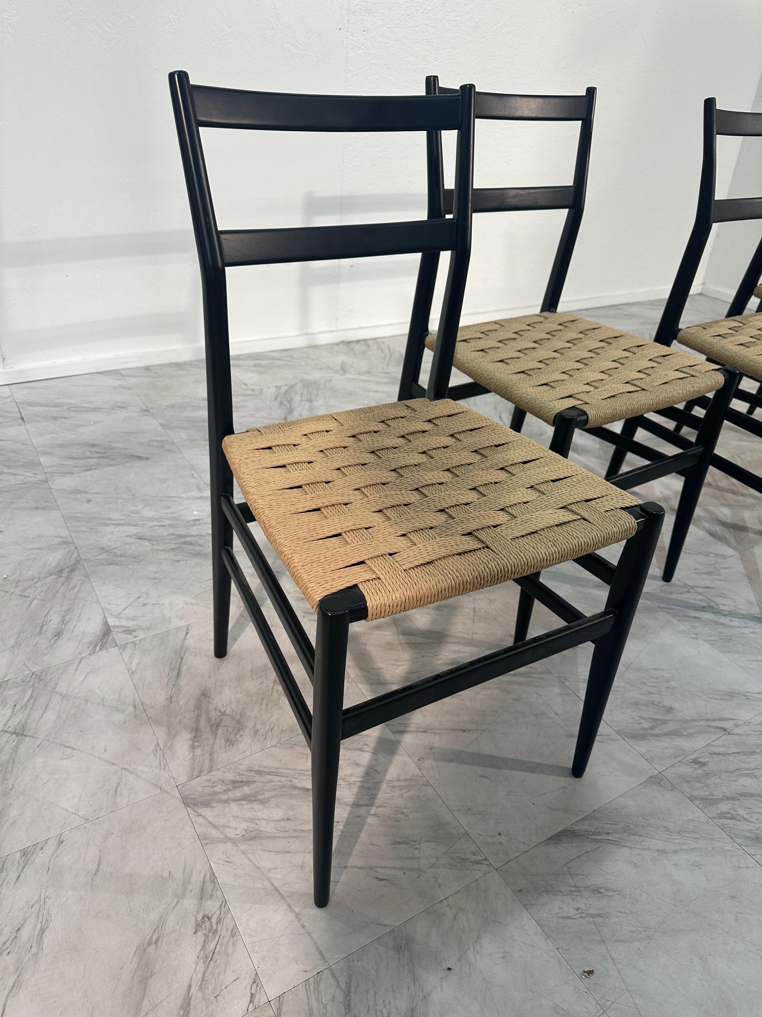 Queste quattro sedie sono state progettate dall'iconico architetto e designer italiano Gio Ponti. Esibiscono il caratteristico stile minimalista di Ponti, che fonde semplicità ed Eleganza. Le strutture sono realizzate in un elegante legno scuro che