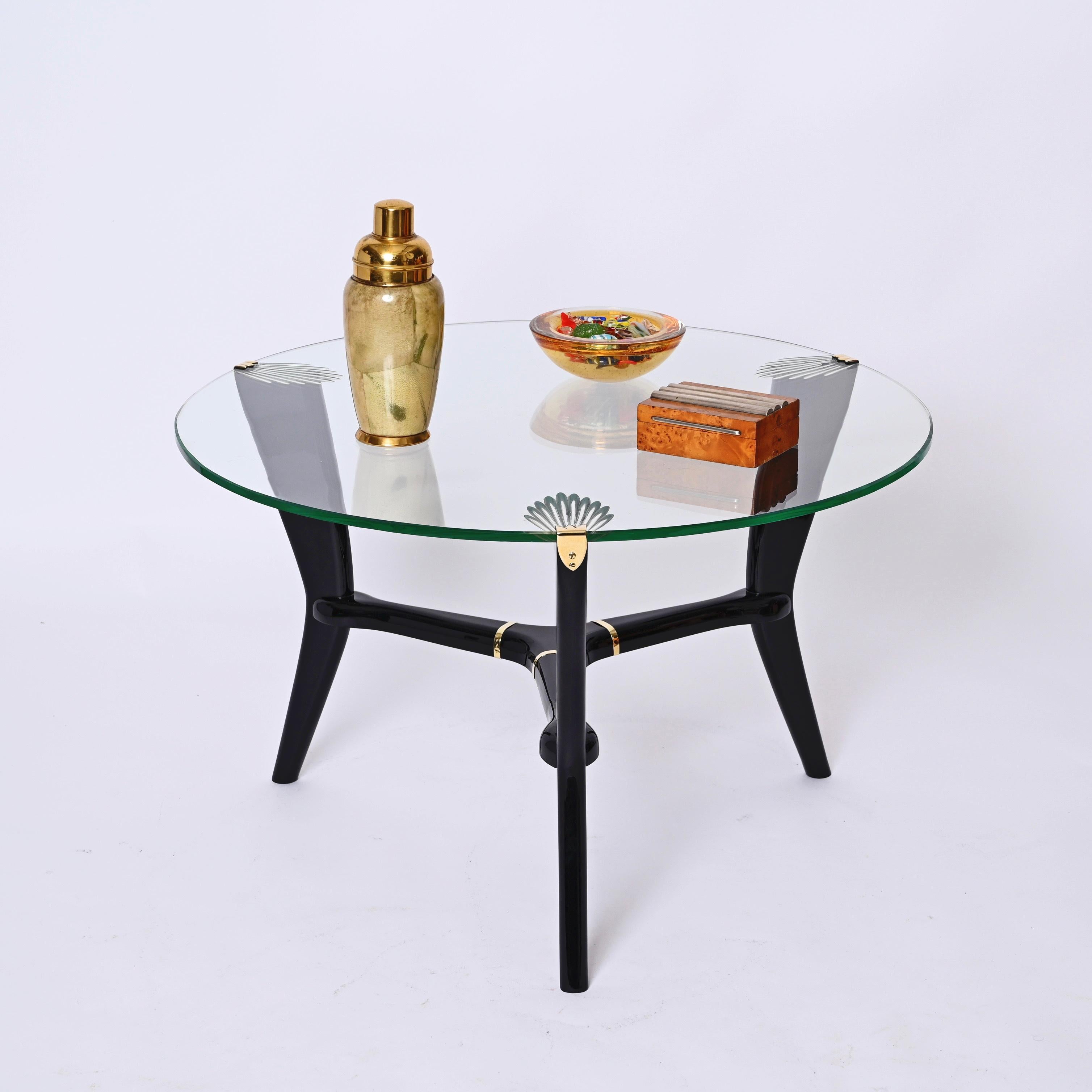 Wonderful art deco ebonized wood, crystal glass round coffee table. This fantastic piece was designed in Italy during the 1940s in the style of Gio Ponti.

This table is unique thanks to its ebonized legs, kept together in the iconic shape through