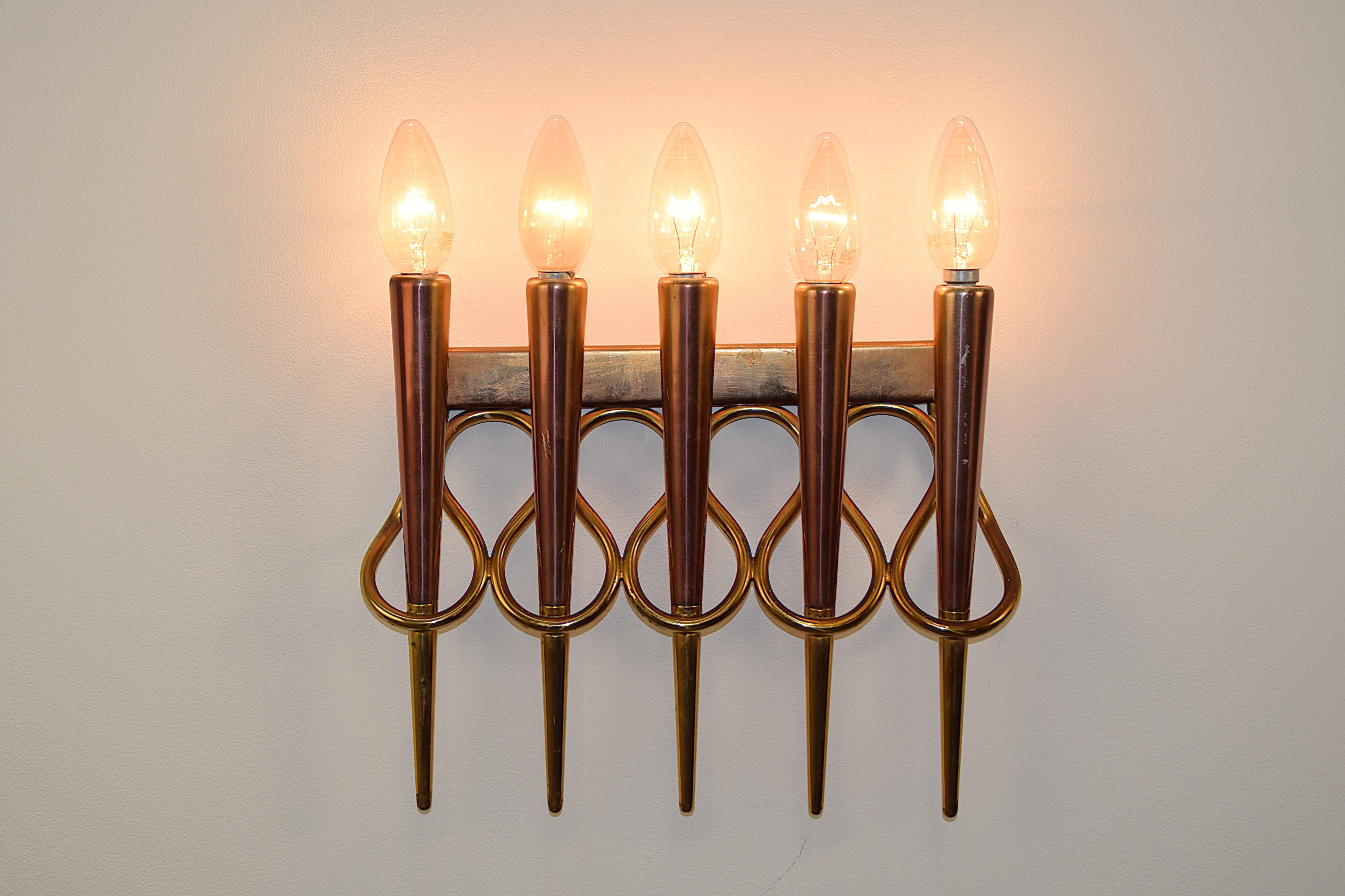 Coppia di lampade da muro attribuite a Gio Ponti, design italiano anni '50, realizzate in ottone e rame. Il raffinato gioco di linee simmetriche e materiali nobili riflette l’eleganza tipica del modernismo italiano dell’epoca. Le lampade, dalle