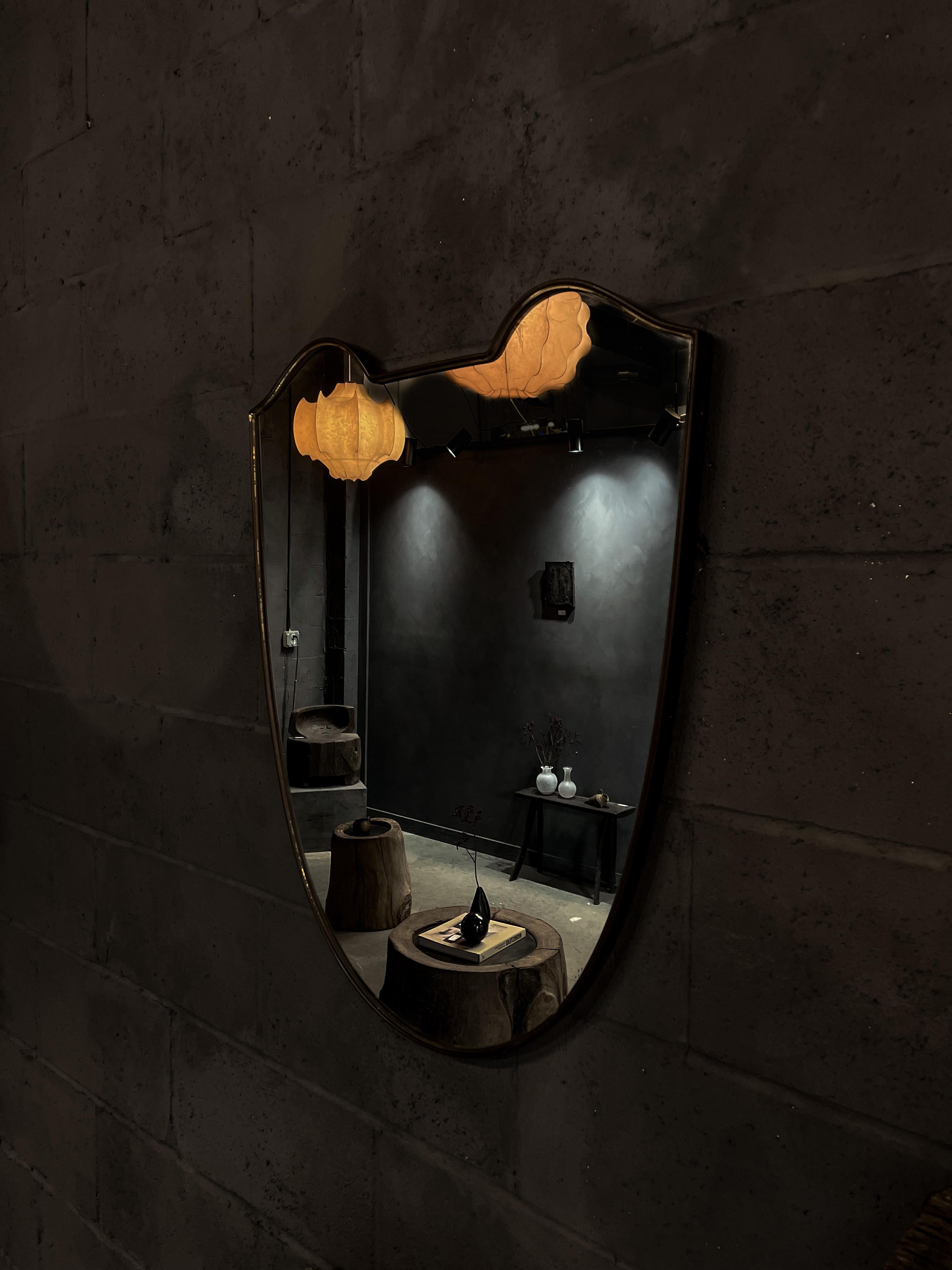 Ce magnifique miroir bouclier en laiton massif attribué à Gio Ponti a été fabriqué en Italie dans les années 1940. Il possède encore son verre d'origine. Un beau design intemporel. 
