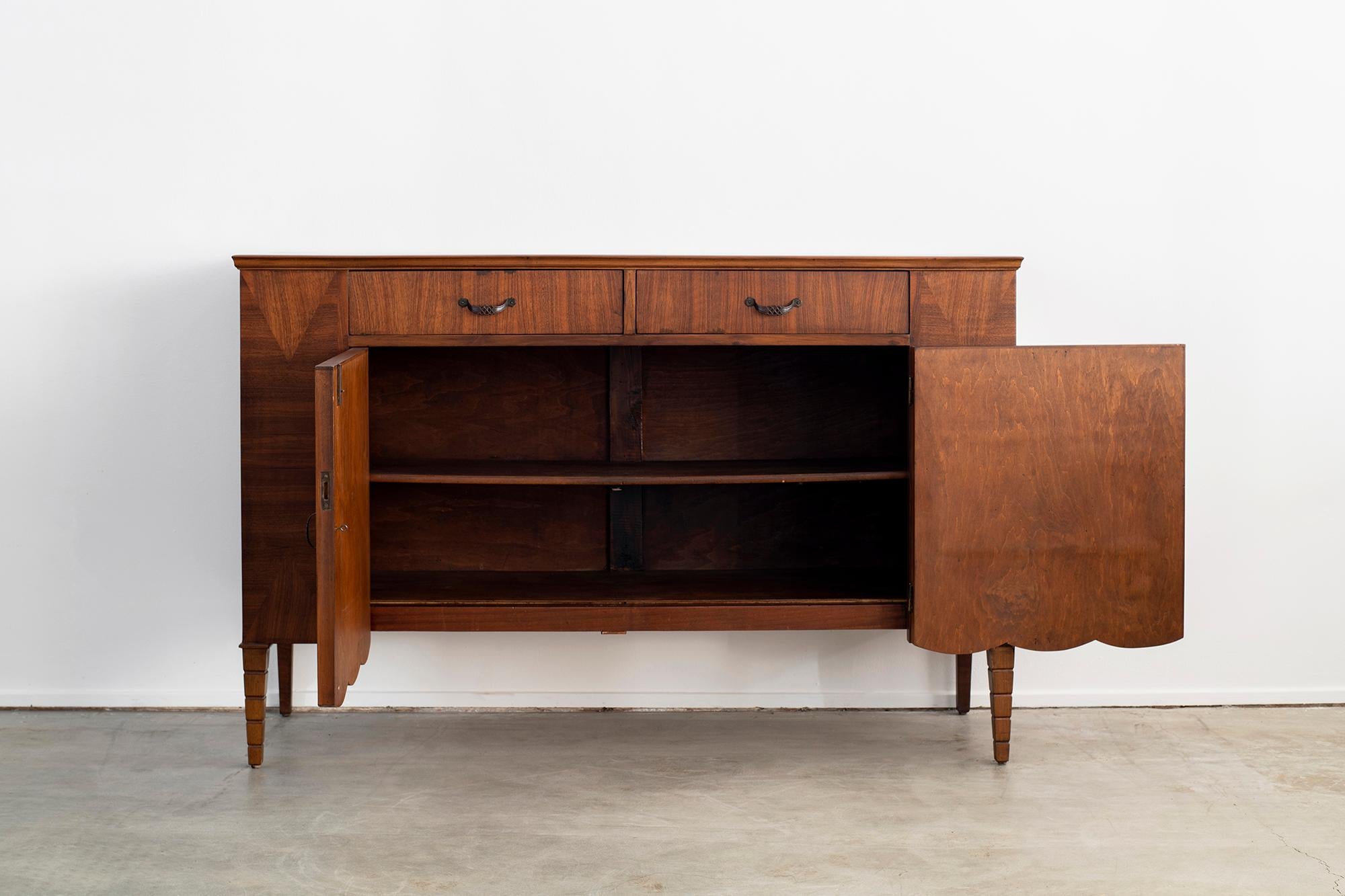 Stunning sideboard attributed to Gio Ponti, circa 1930s
Intricate wood inlay and pattern to the wood with scalloped edged bottom
Ornately carved tapered legs
Original hardware and key
2 cabinet doors open to reveal shelves and 2 upper