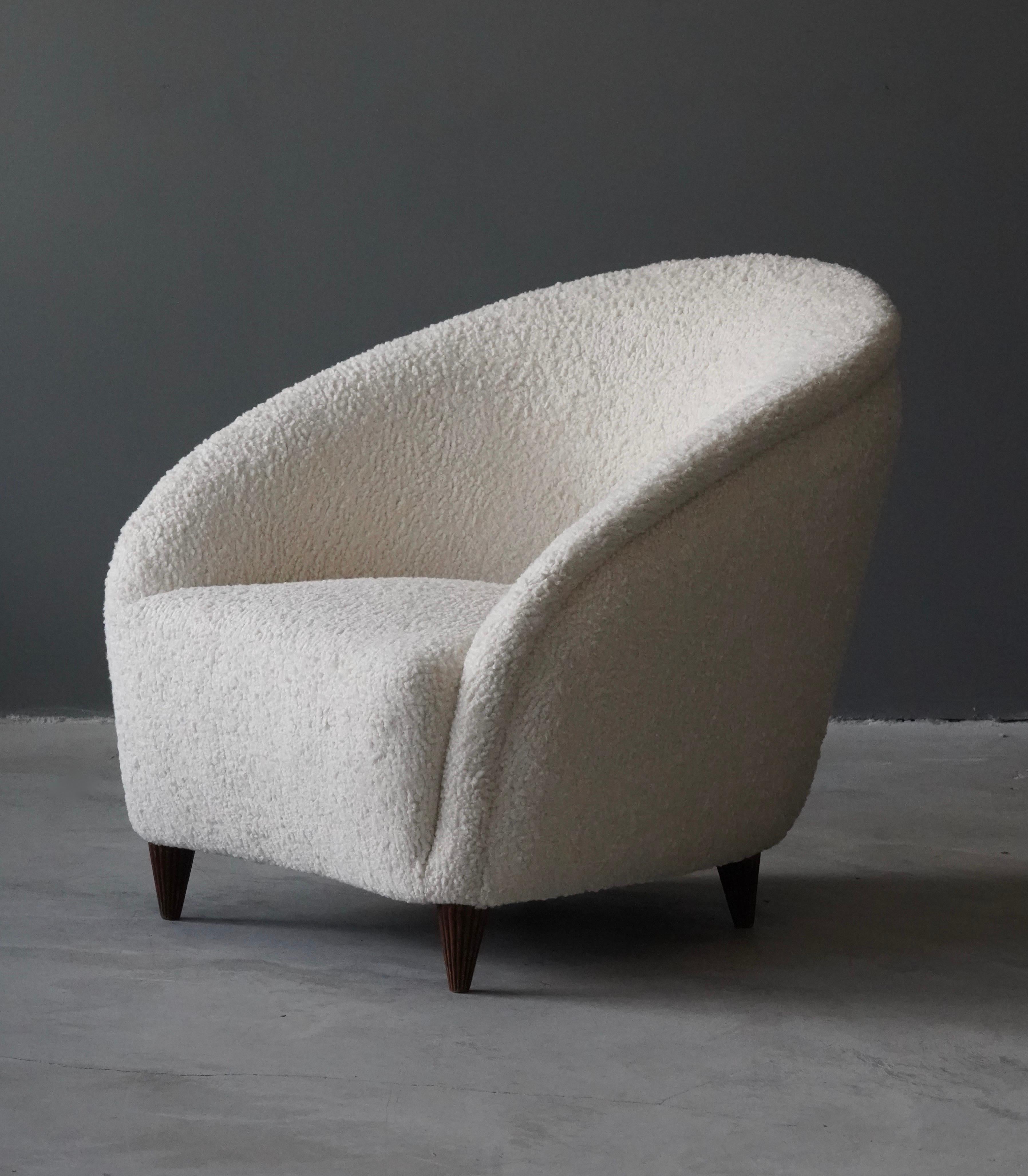 Organically shaped lounge chair of intimate scale, design attributed to Gio Ponti. Likely produced by Casa e Giardino in the 1940s. Reupholstered in a high-end white bouclé fabric. Fluted walnut legs with light original patina. 

Gio Ponti is